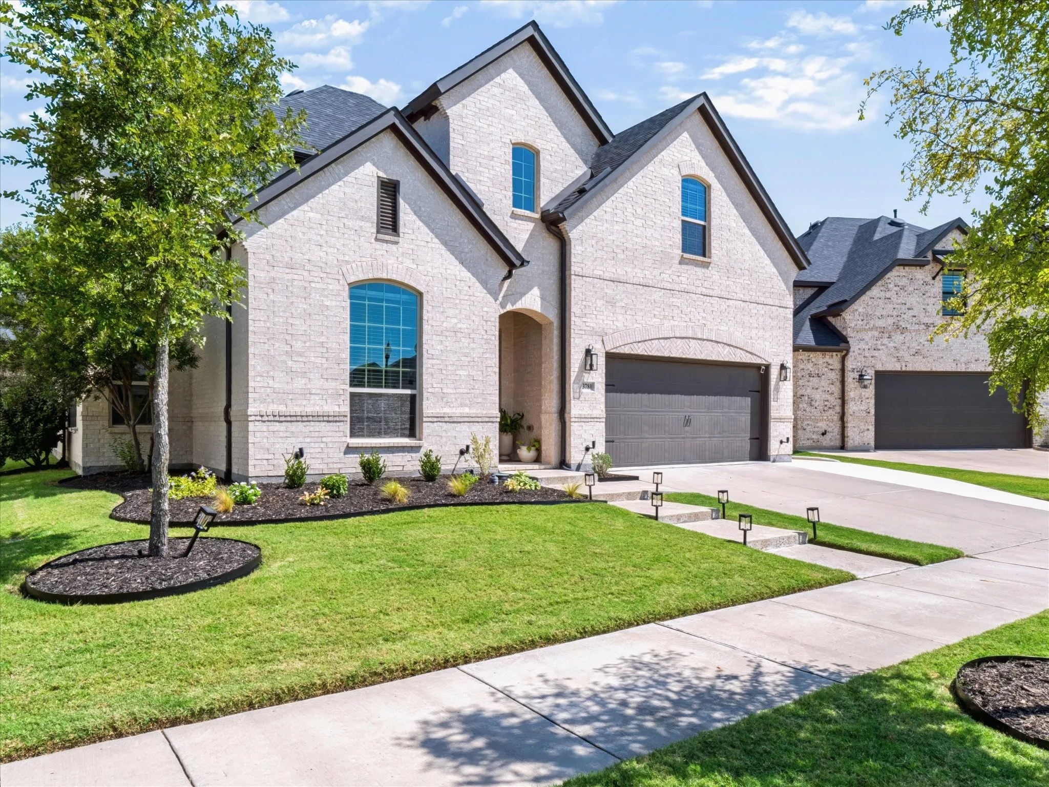 Light-colored brick exterior with dark trim and a dark-shingled roof