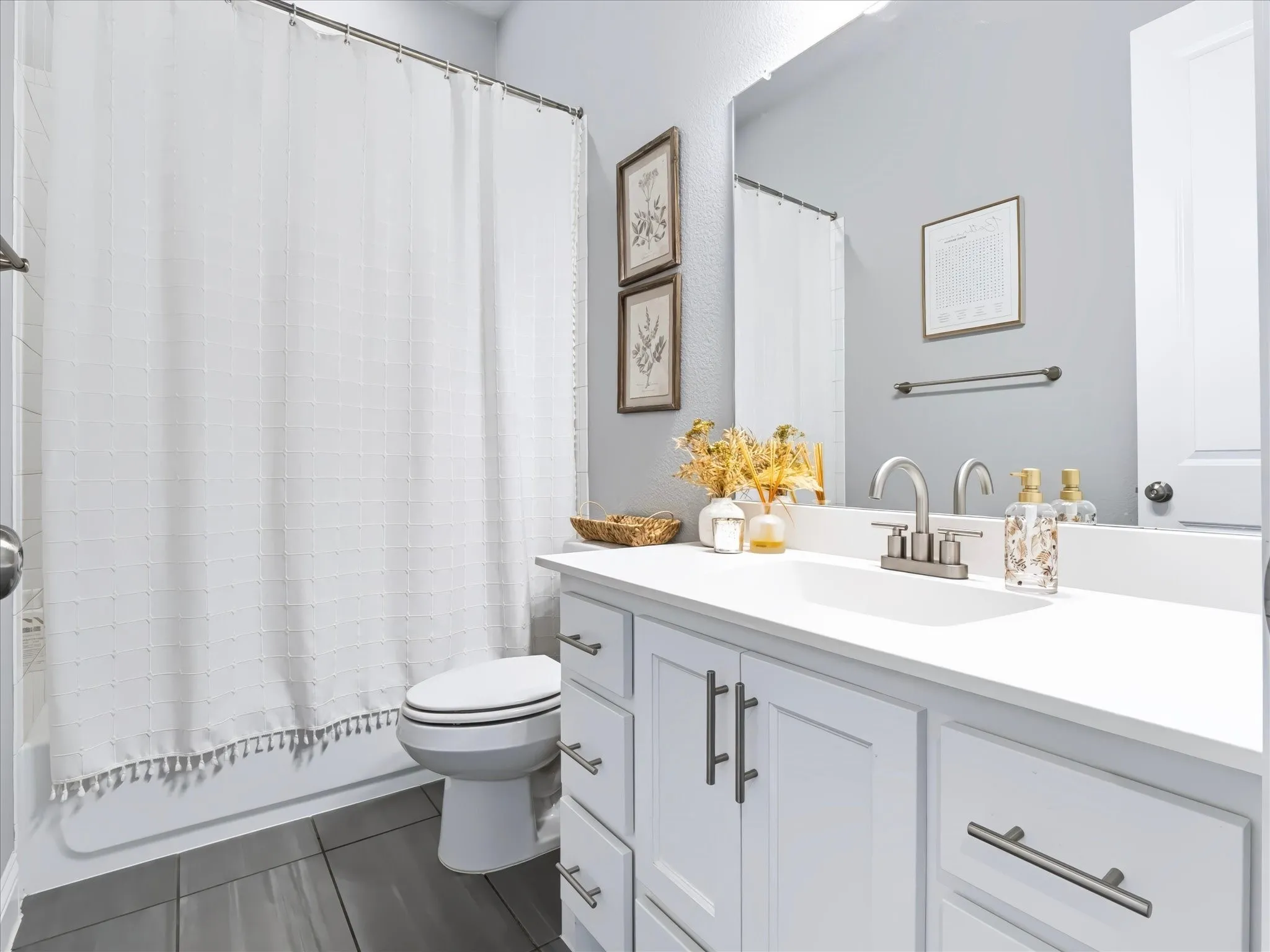 White vanity with brushed nickel hardware, integrated rectangular sink, and single-handle faucet