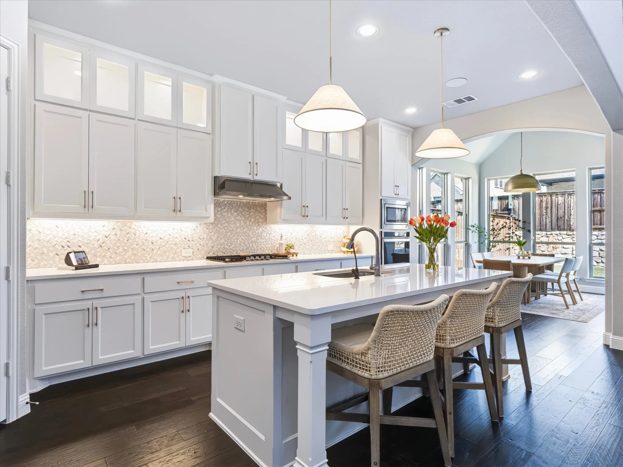 Kitchen featuring white floor to ceiling cabinetry, a large central island, dark wood-finish flooring, and recessed lighting