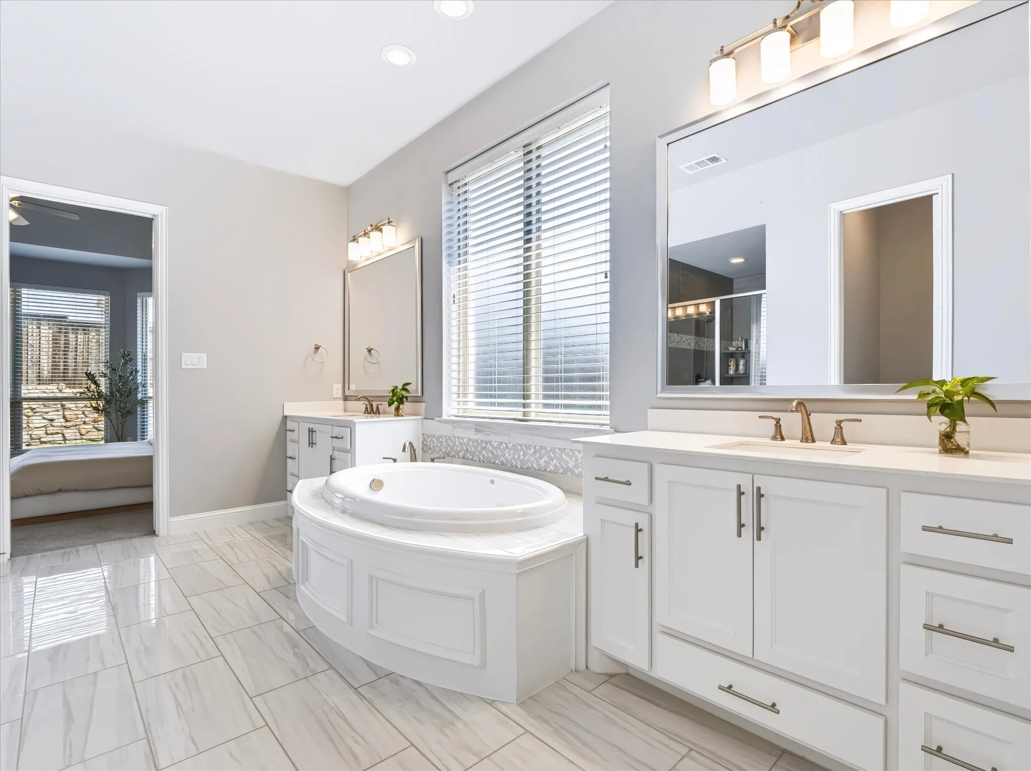 Tiled flooring, dual vanities with integrated sinks, recessed lighting, and a built-in soaking tub