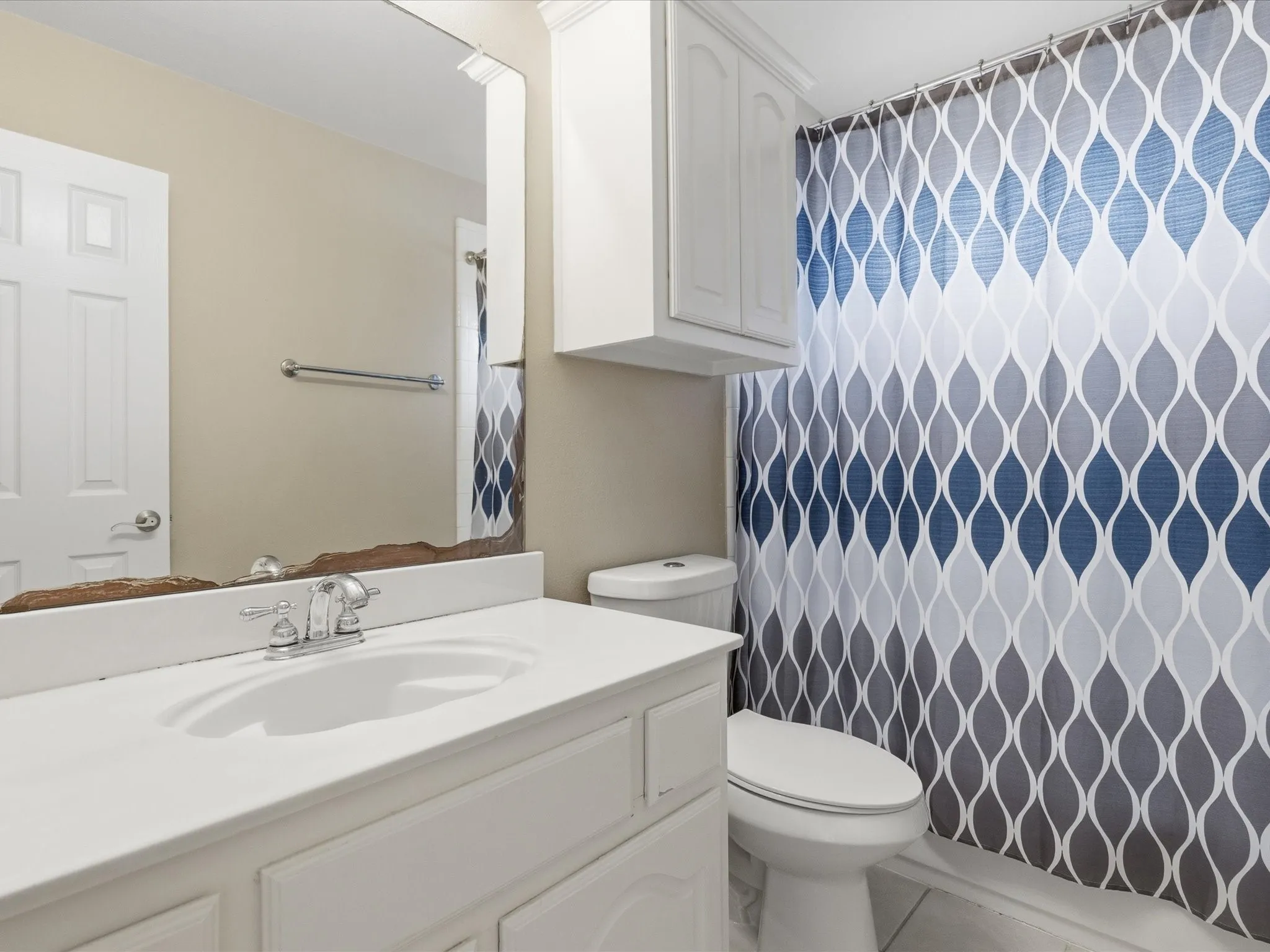 Bathroom featuring a white vanity with an integrated sink, chrome faucet, and a wall-mounted mirror