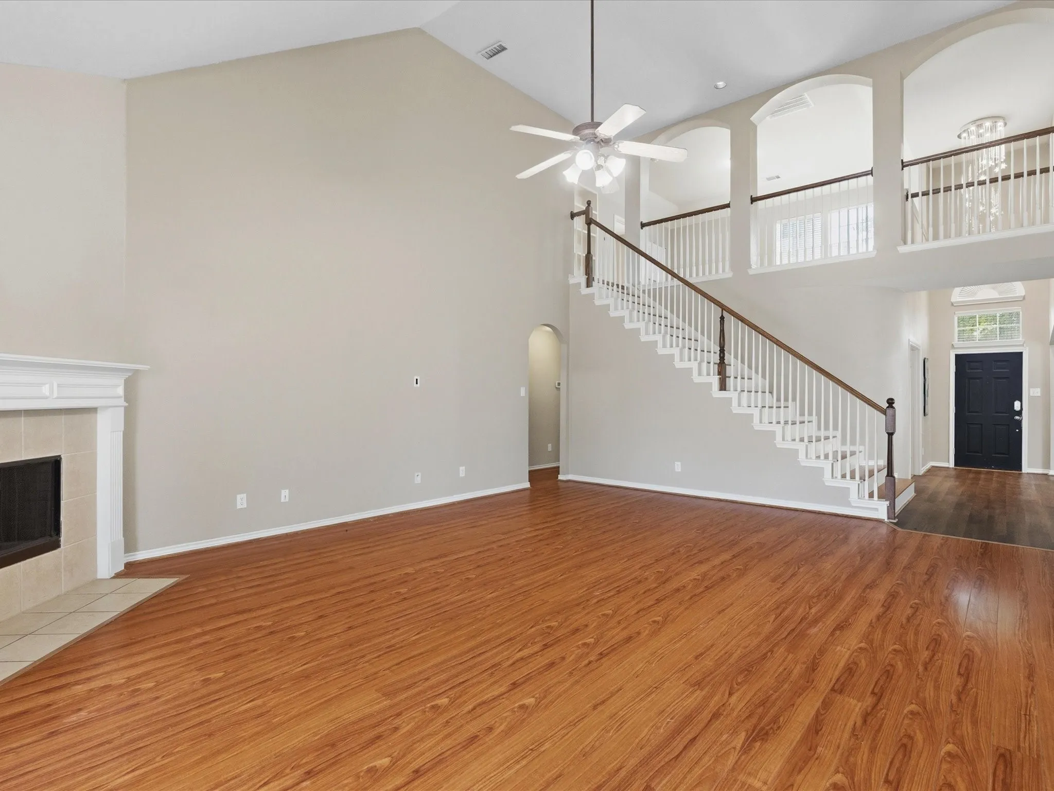Spacious main living area featuring soaring ceilings and wood-finish flooring