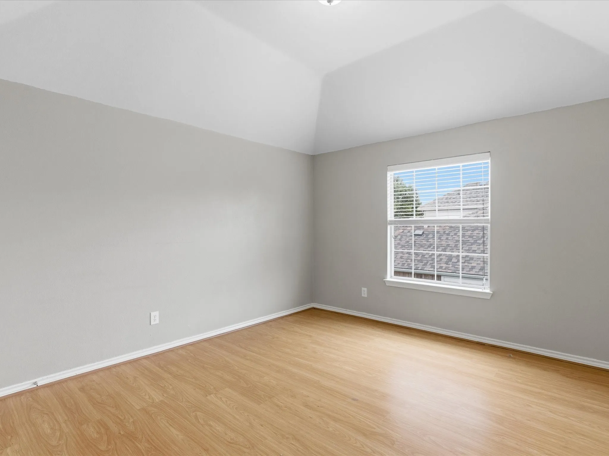 Room featuring wood-finish flooring, light gray wall paint, and white baseboards