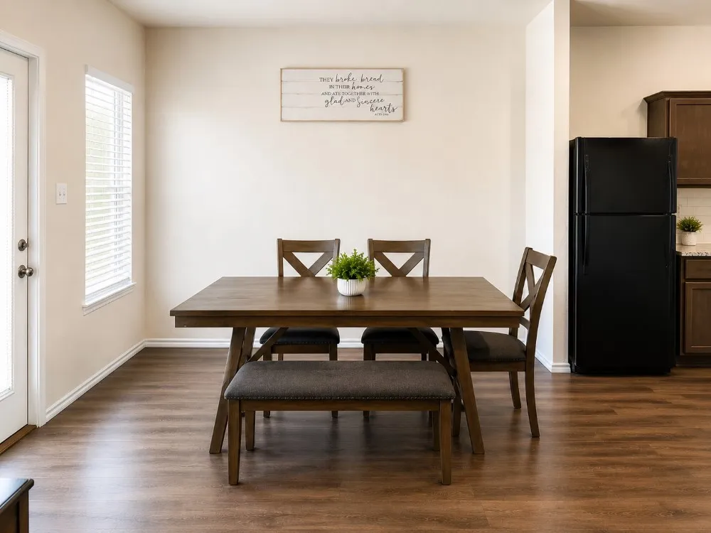 Dining area featuring wood-finish flooring, light neutral wall tones, and a window with blinds