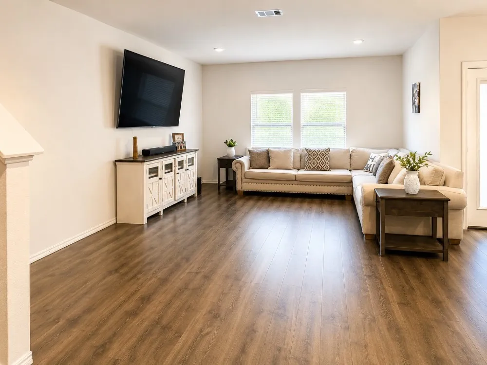 Spacious living area featuring wood-finish flooring, recessed lighting, and ample natural light from multiple windows