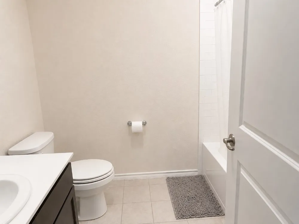 Full bathroom featuring a white porcelain tub, subway tile surround, and a vanity with a white countertop and dark wood-finish cabinetry