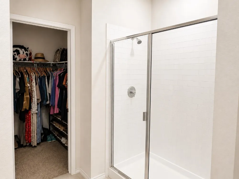 Walk-in shower with clear glass enclosure and subway tile surround