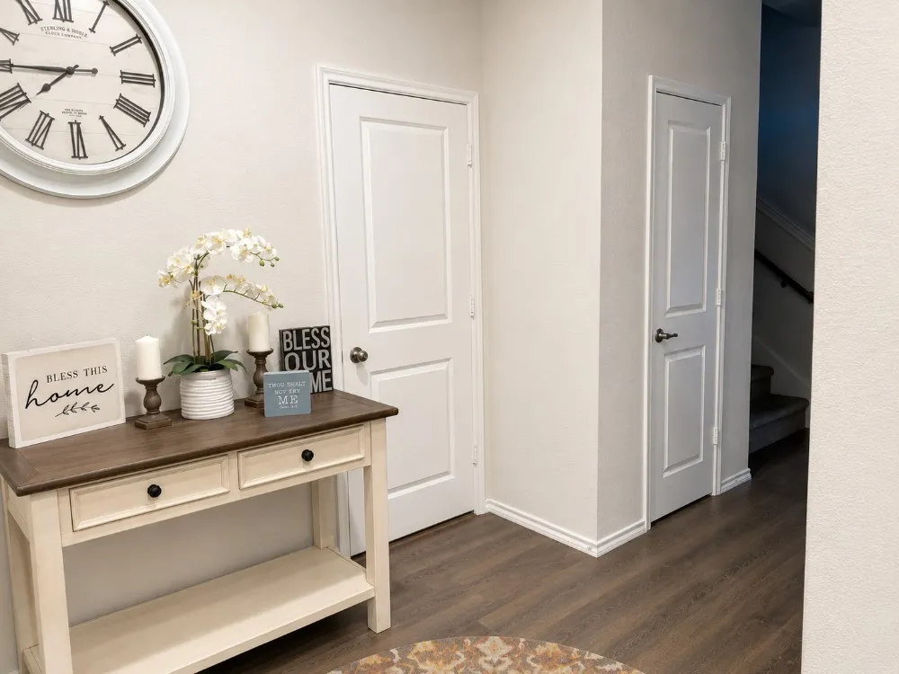 Inviting entryway featuring wood-finish flooring, crisp white baseboards, and two-panel interior doors