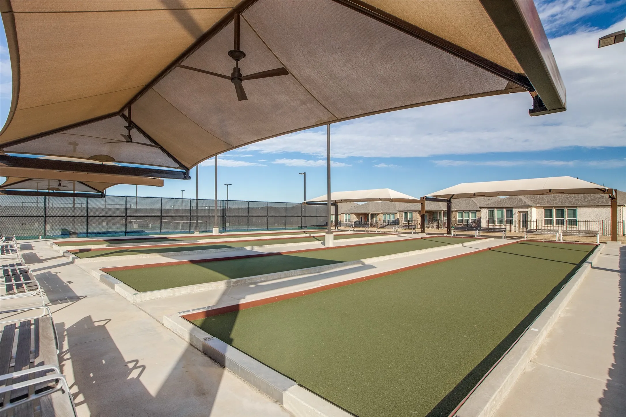 Shaded bocce ball courts with concrete surrounds and integrated ceiling fans