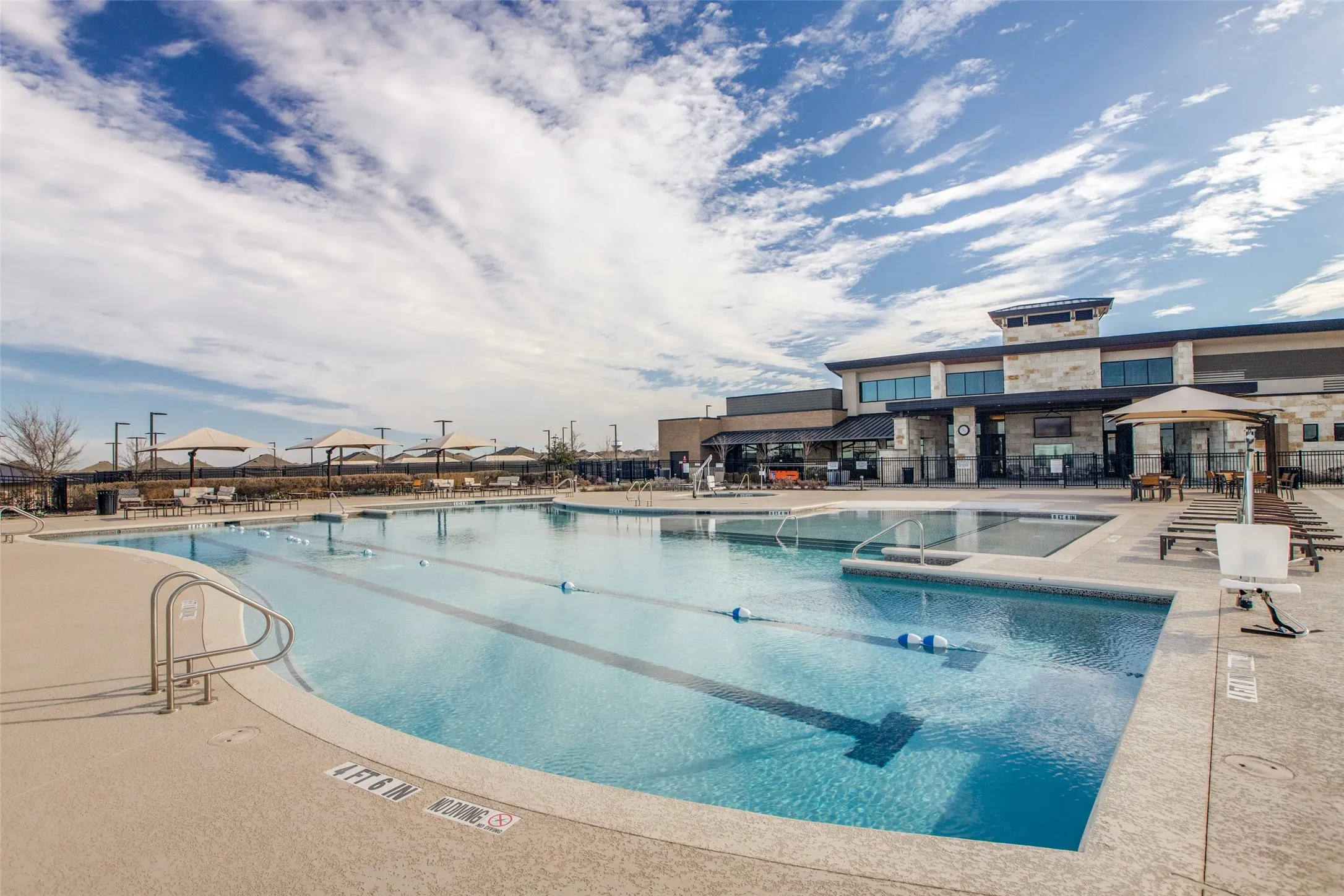 Resort-style aquatic amenity featuring multiple pools, integrated spa, and expansive paved decking
