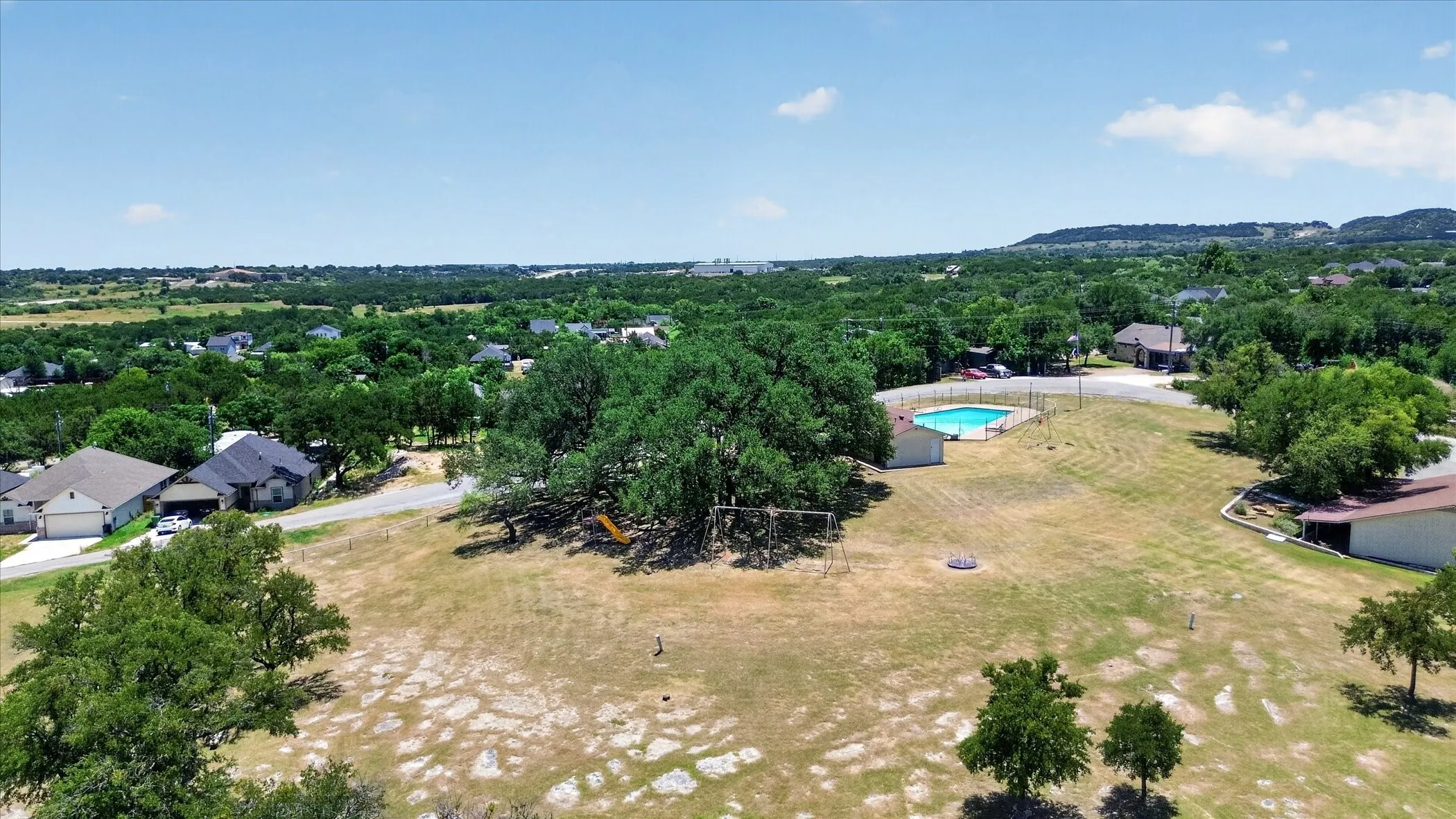 HOA property featuring a large open field used for soccer, and arhcry, mature trees, and a swimming pool