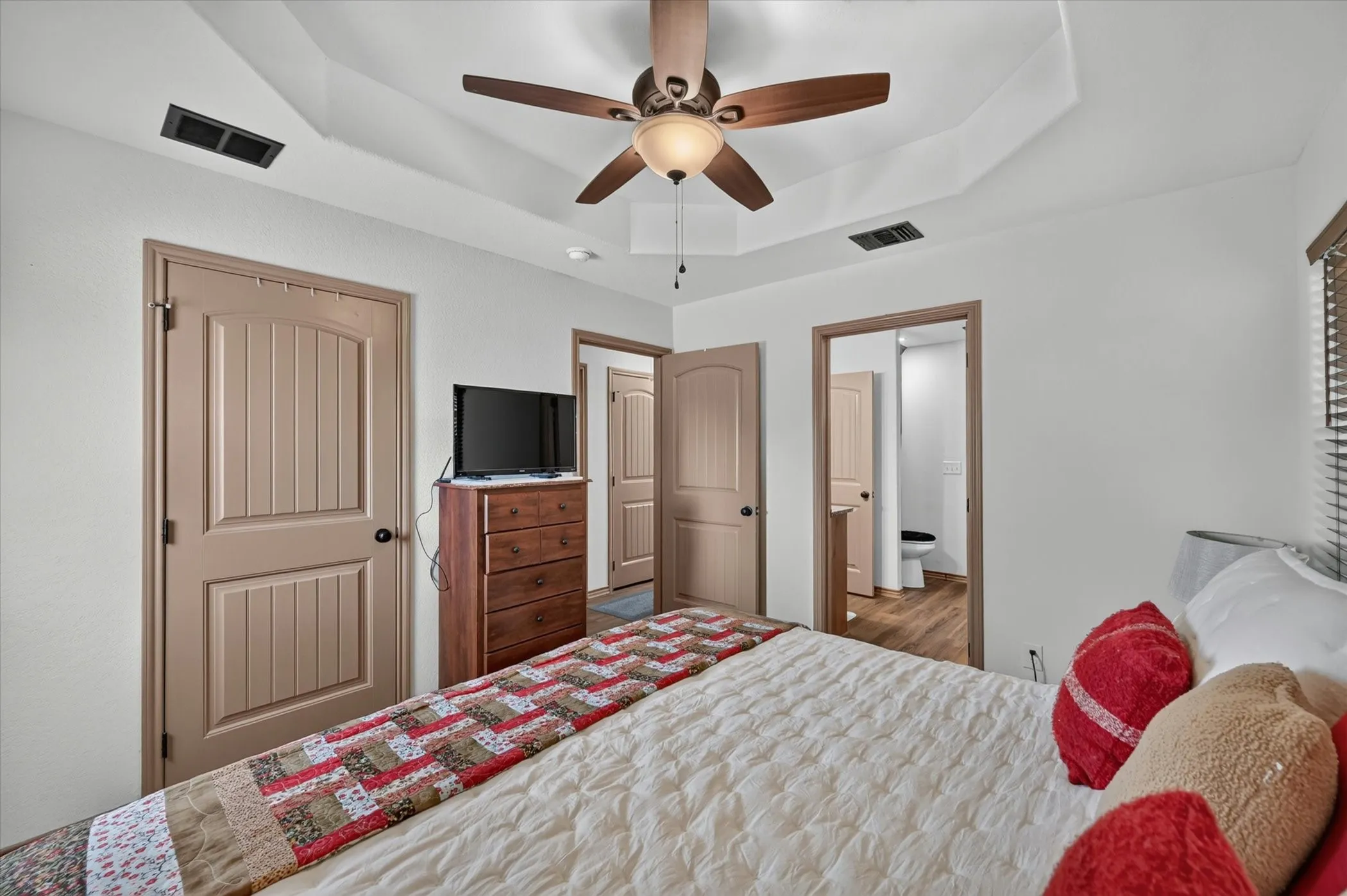 Room featuring a tray ceiling with a ceiling fan, light wood-finish flooring, and recessed lighting