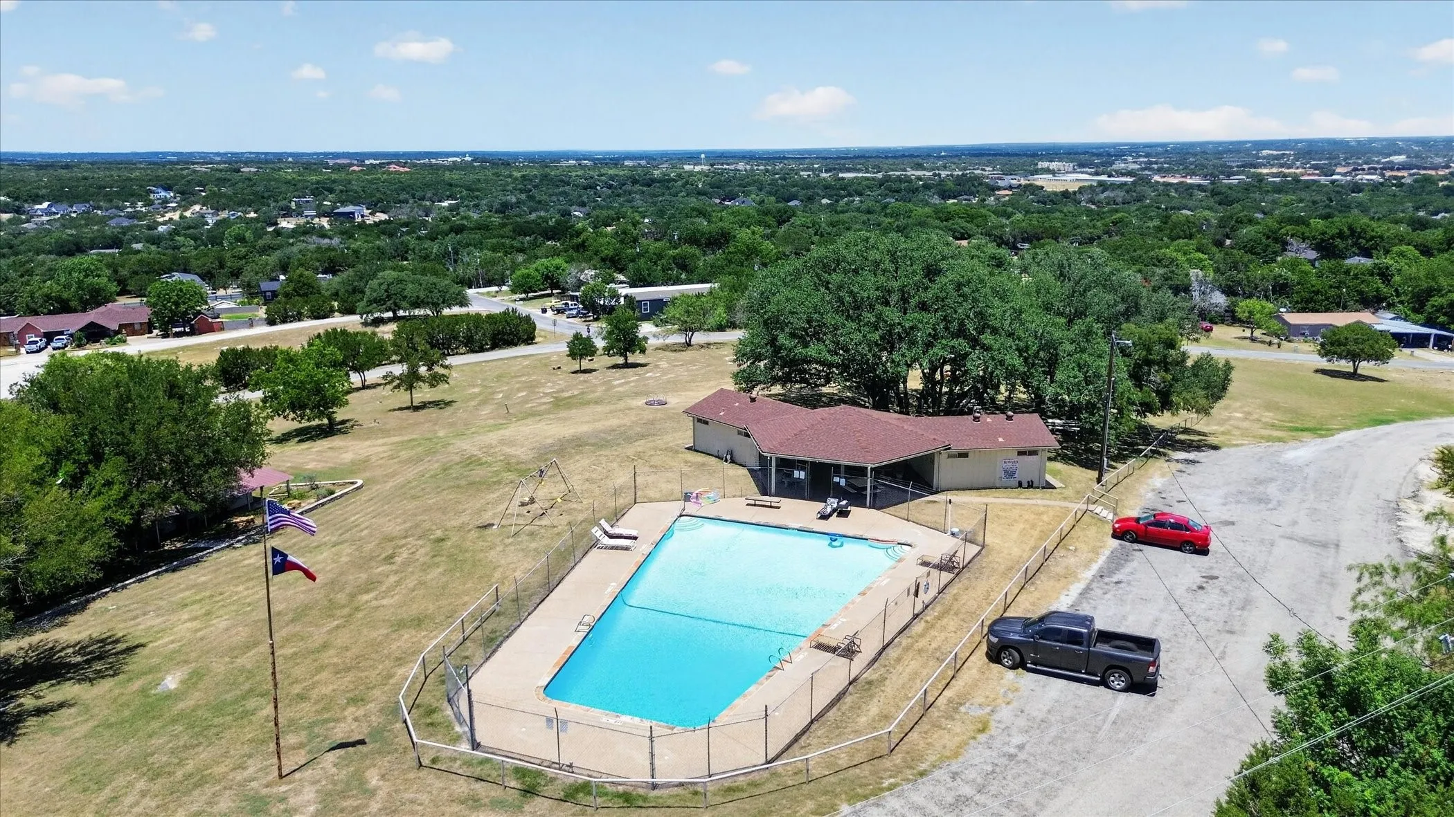 Concrete decking, chain link fencing, and an adjacent building