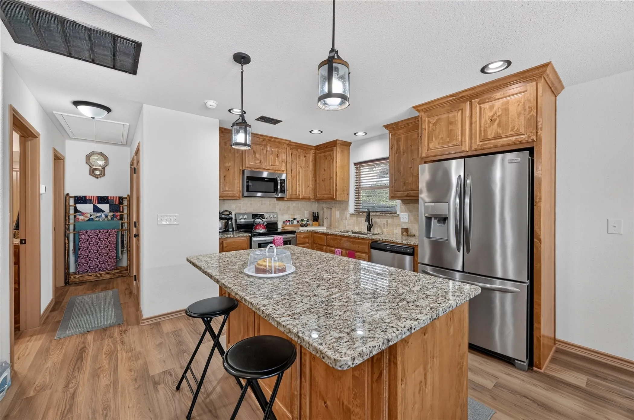 Kitchen featuring wood-finish flooring, recessed lighting, and a center island with a speckled countertop