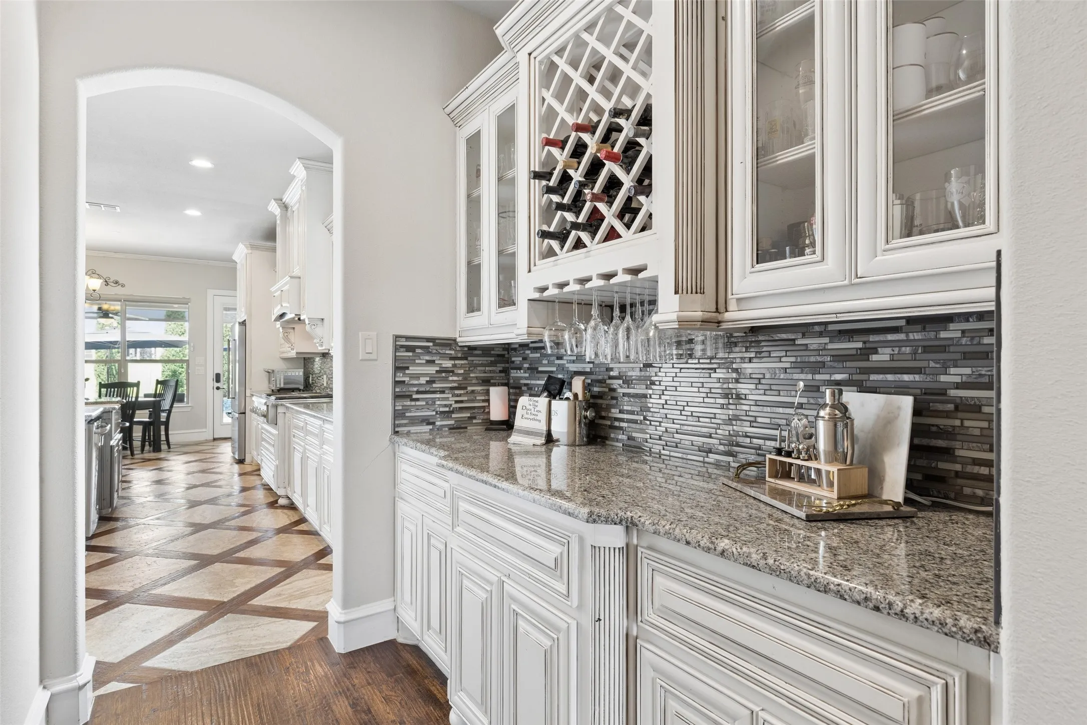 Custom built-in cabinetry with glass-front uppers, an integrated wine rack, and stemware storage