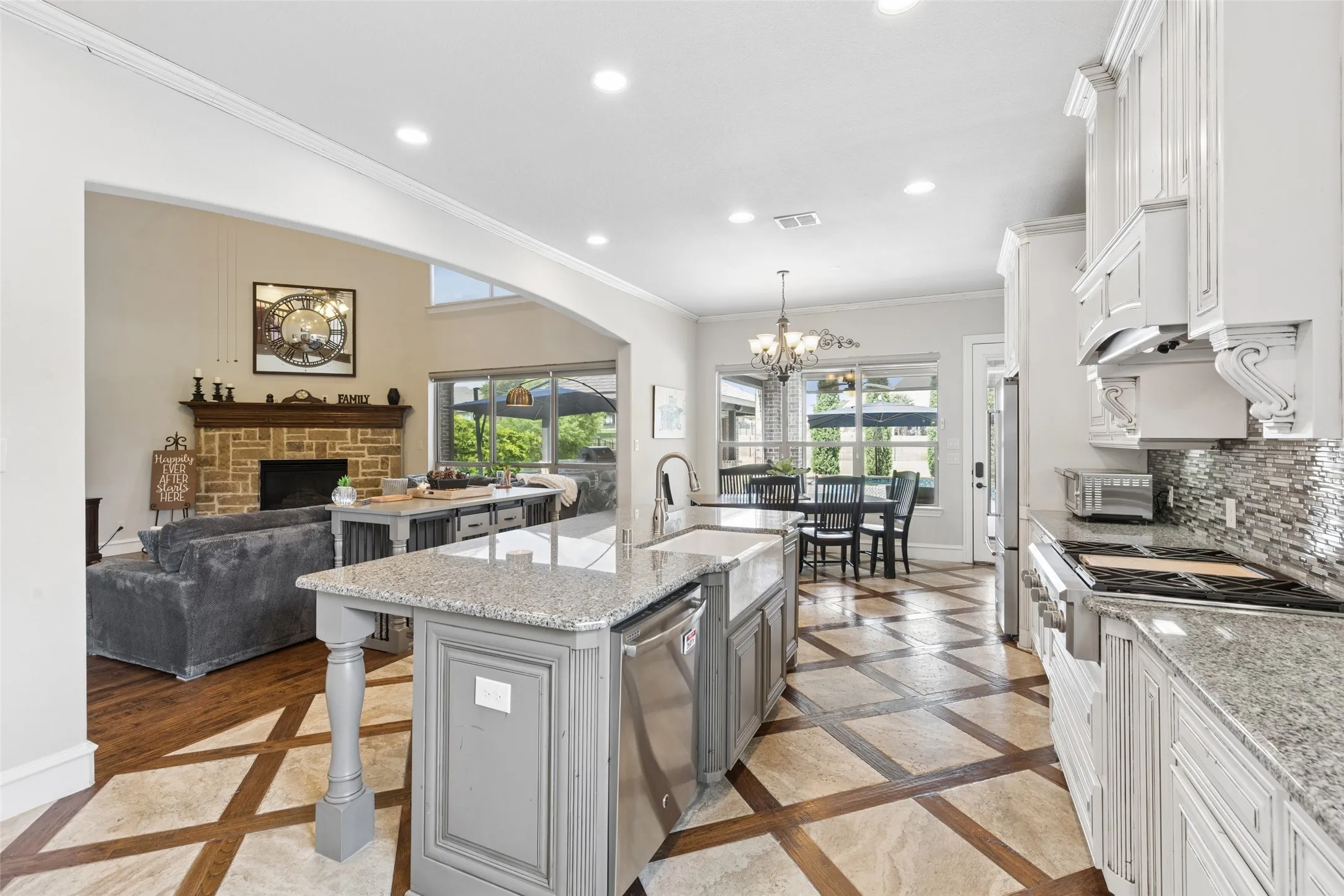 Gourmet kitchen featuring a large island with granite countertops and an integrated farmhouse sink