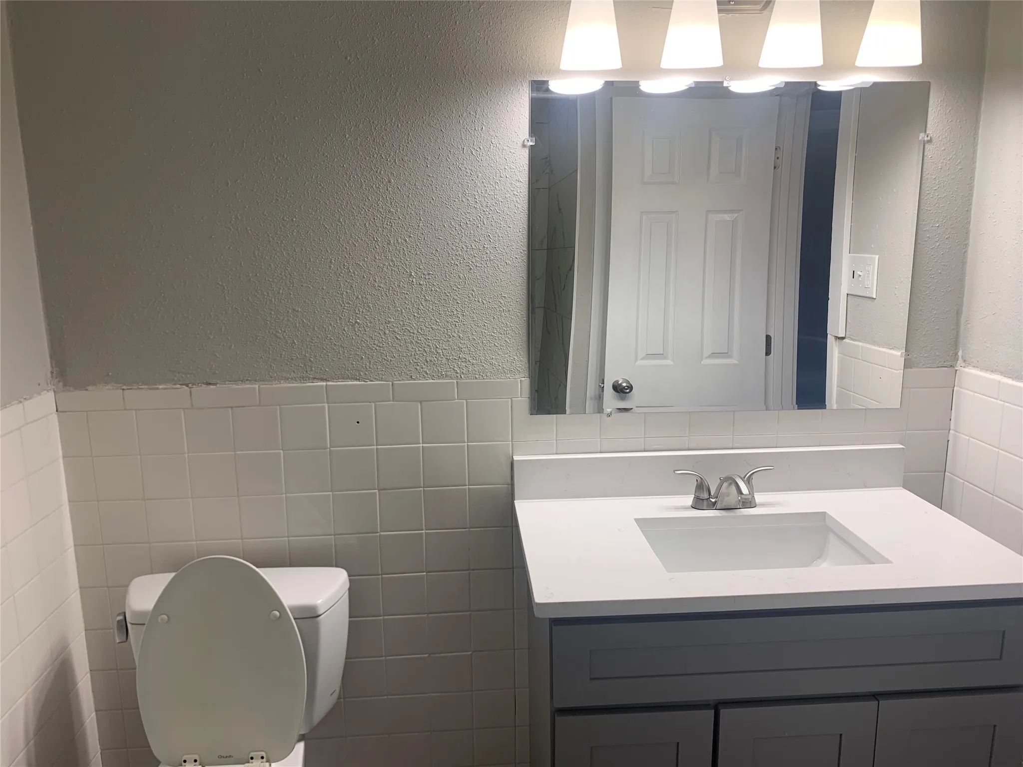 Vanity featuring a white countertop with an integrated rectangular sink