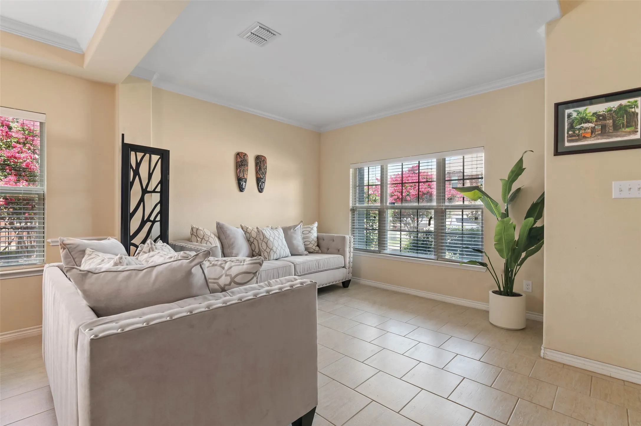 Spacious interior featuring neutral tone walls, tile flooring, and large windows with blinds