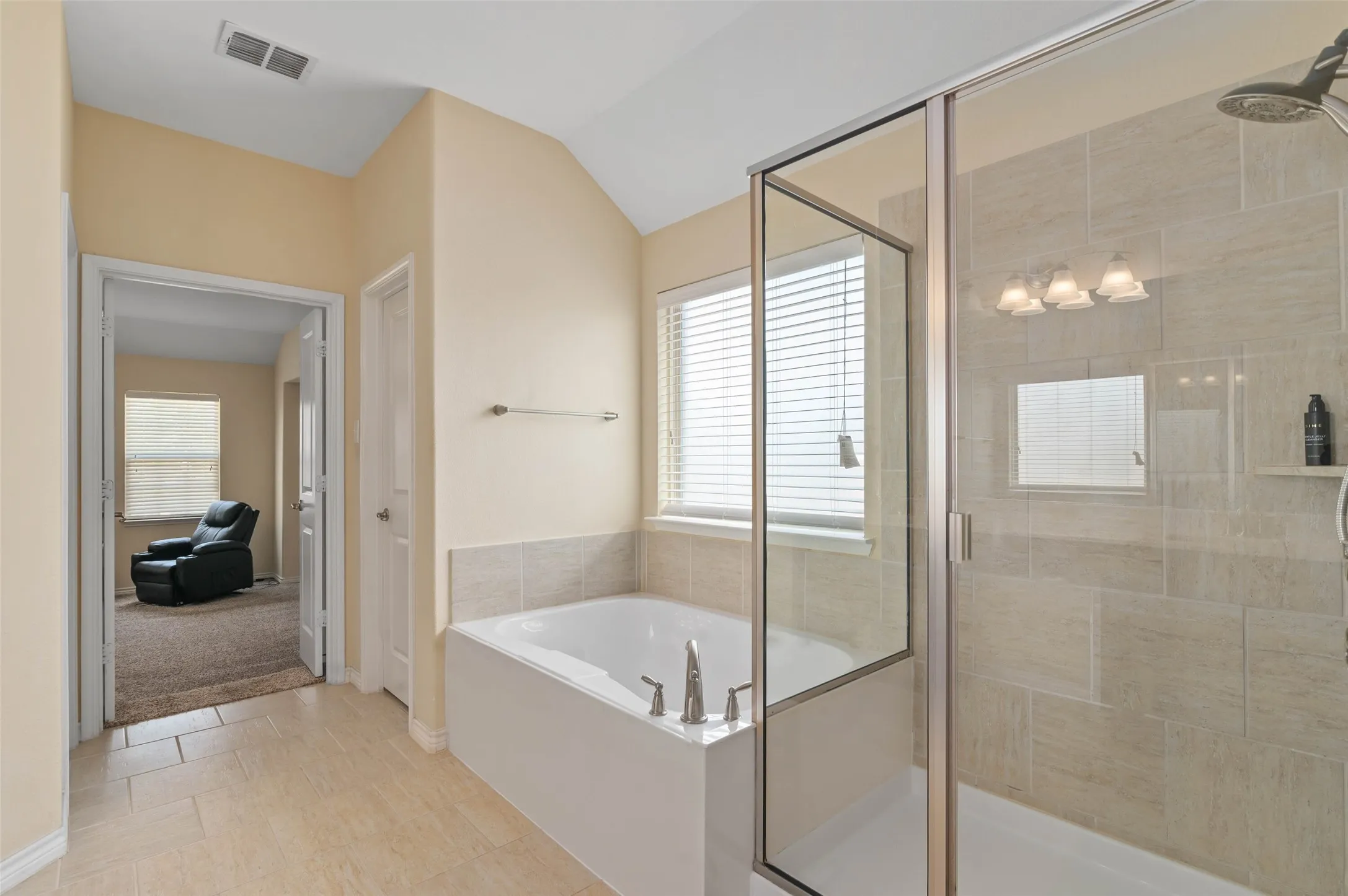 Tiled flooring complementing a built-in soaking tub with brushed nickel fixtures