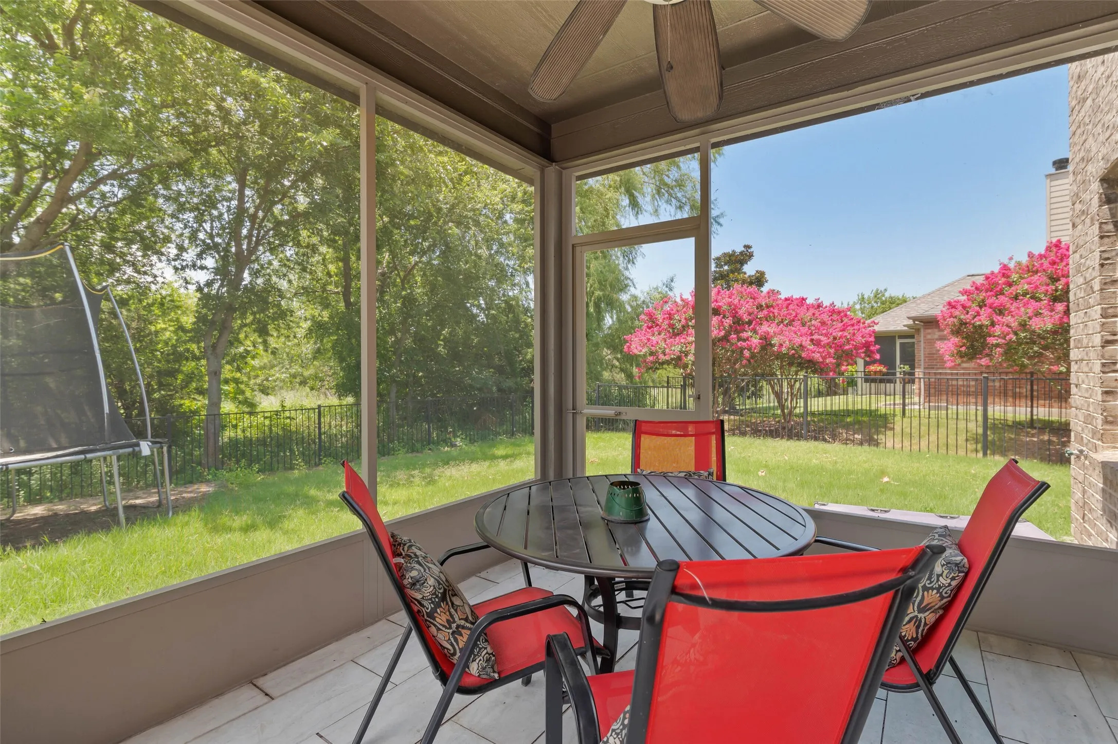 Screened porch with tile flooring and a ceiling fan