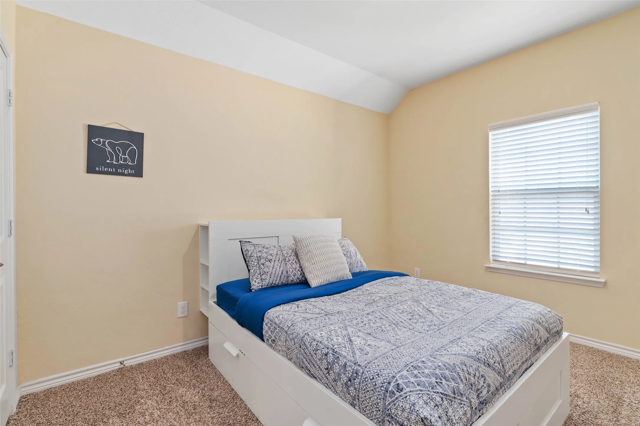 Carpeted room with neutral-toned walls, white trim, and a single window featuring horizontal blinds