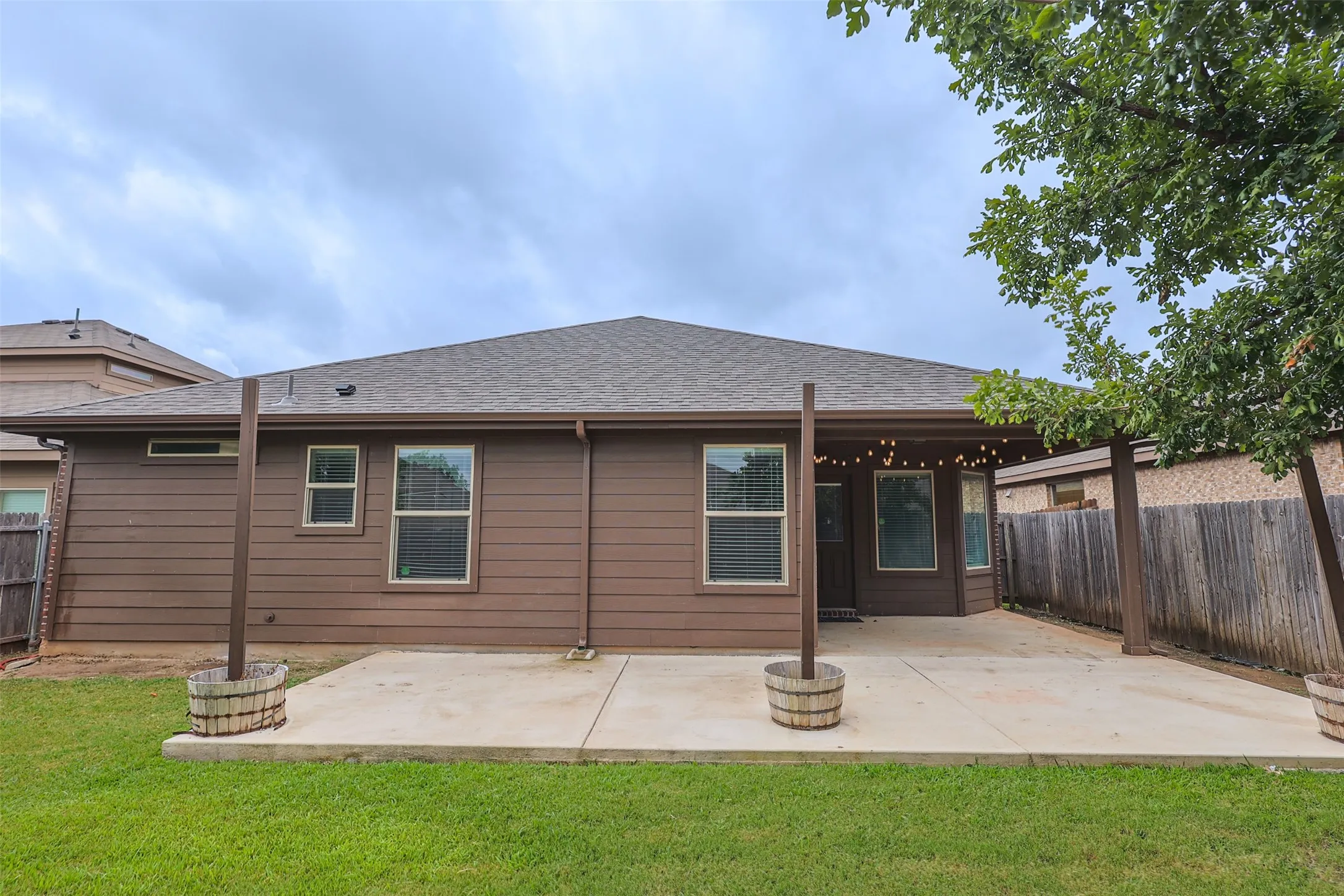 Rear exterior featuring a brown siding facade and a gray shingle roof