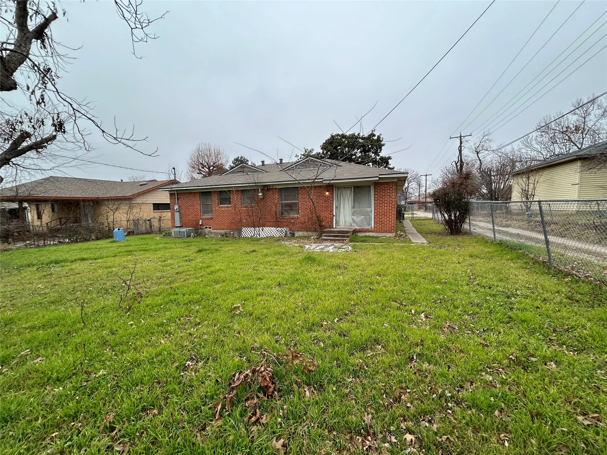Rear view of house featuring brick siding and entry steps