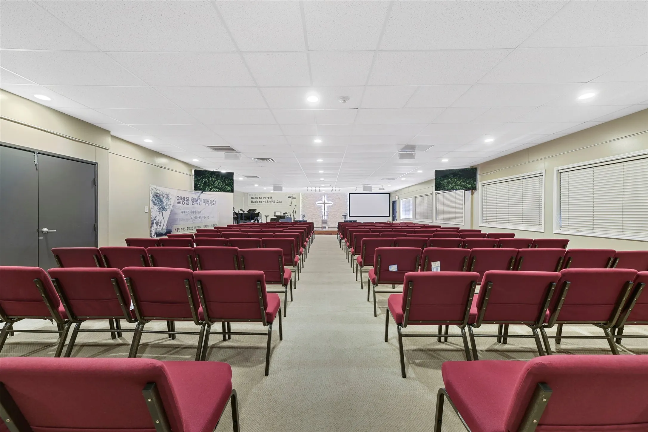 Spacious interior featuring neutral-toned walls, recessed lighting, and an acoustical tile ceiling