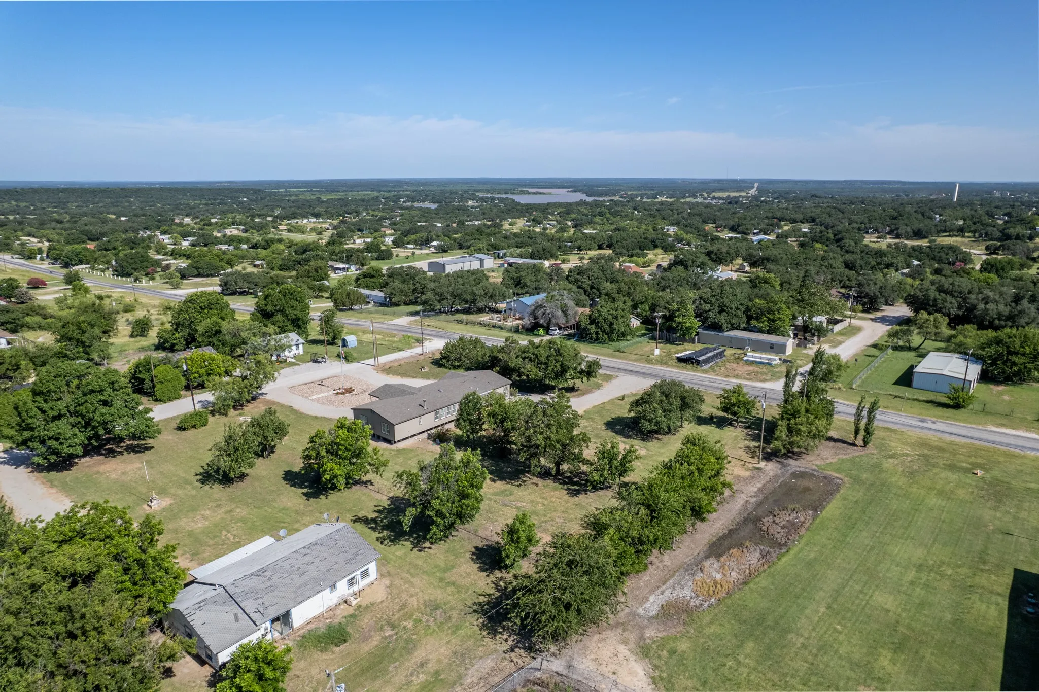 Expansive landscape featuring widespread tree cover, a clear sky, and visible roadways