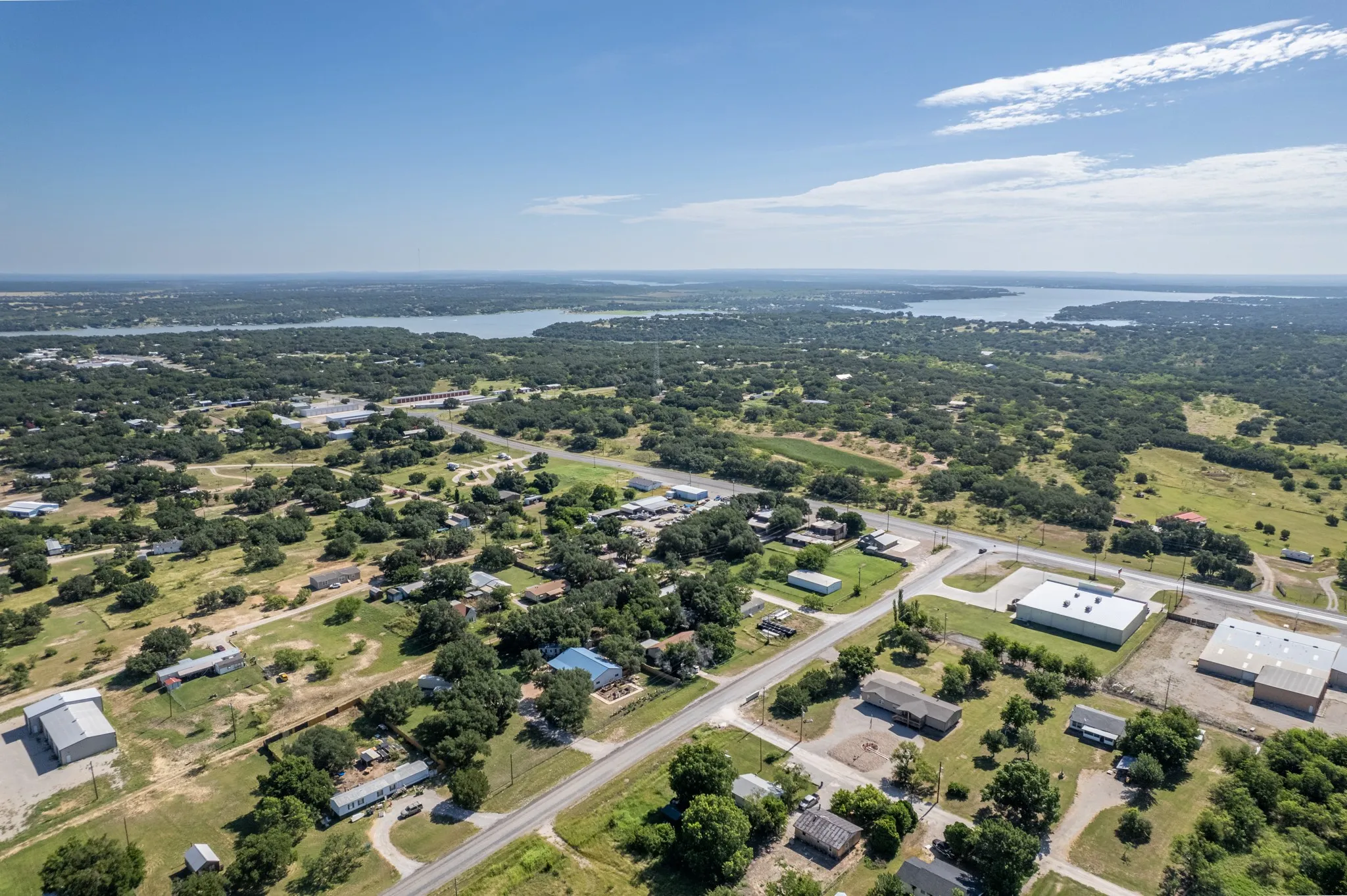 Expansive aerial perspective showcasing a significant body of water and a landscape characterized by abundant mature trees