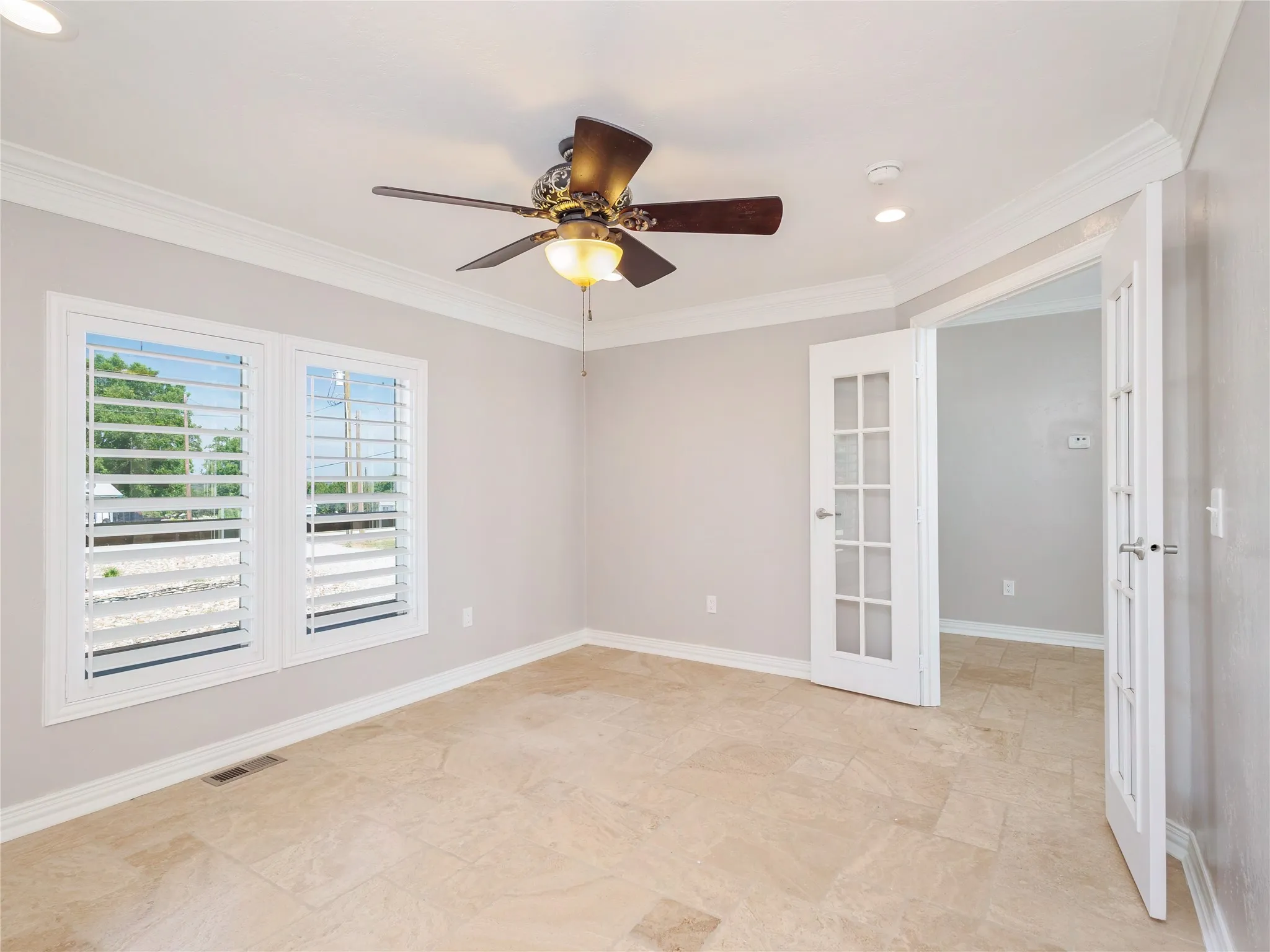 Light-filled interior space featuring neutral wall tones and tile flooring