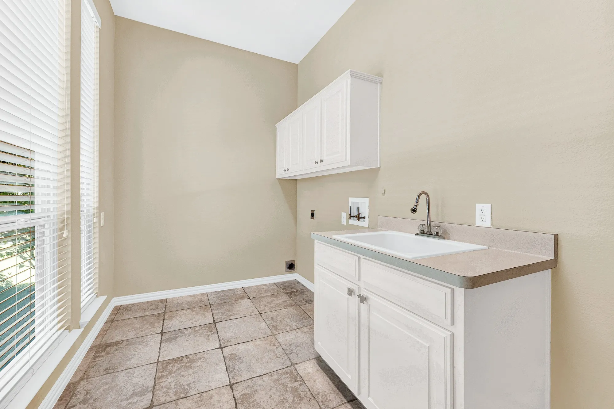 Fantastic laundry room with utility sink, cabinets and windows for natural sunlight!