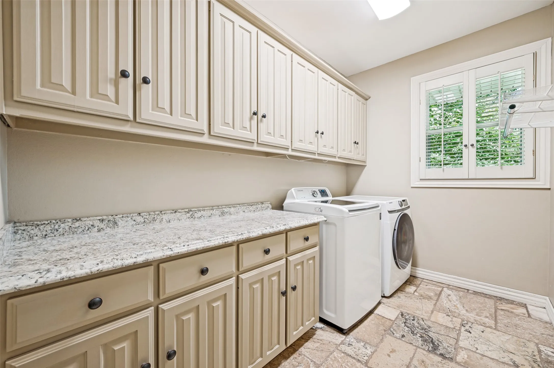 Lots of cabinets, granite counter for folding clothes, a hanging spot and an ironing board that folds into the wall!