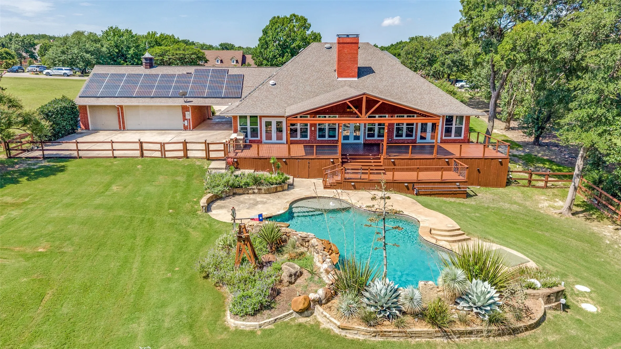 Great view of what the back of the home offers! Large driveway area to turn cars and park. Garage doors face the back as well as the solar panels. The huge porch and shaded area. The custom pool, waterfall and amazing landscaping!!