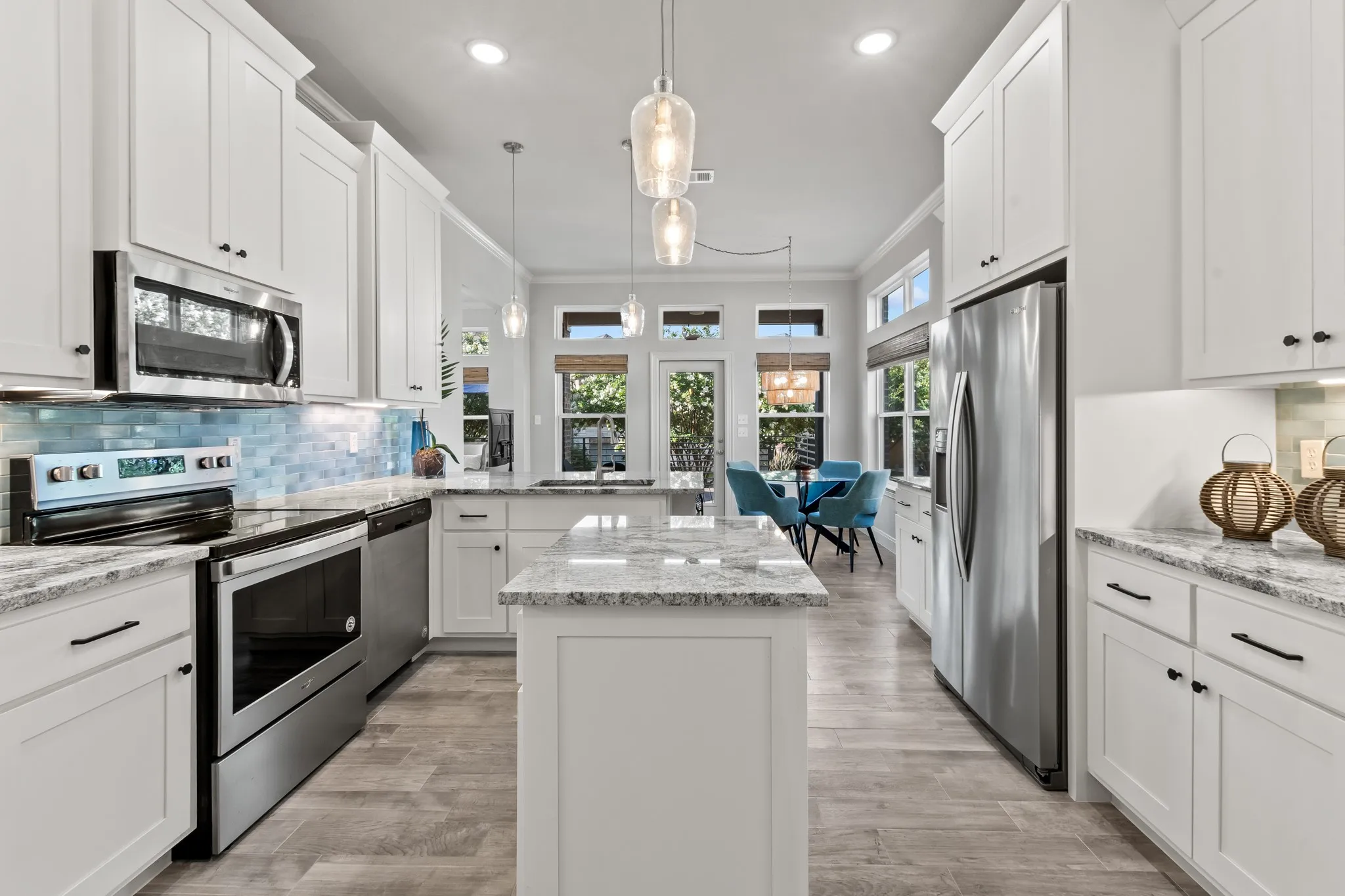 Kitchen with shaker style cabinetry, blue tile back splash, granite counter tops and kitchen island.