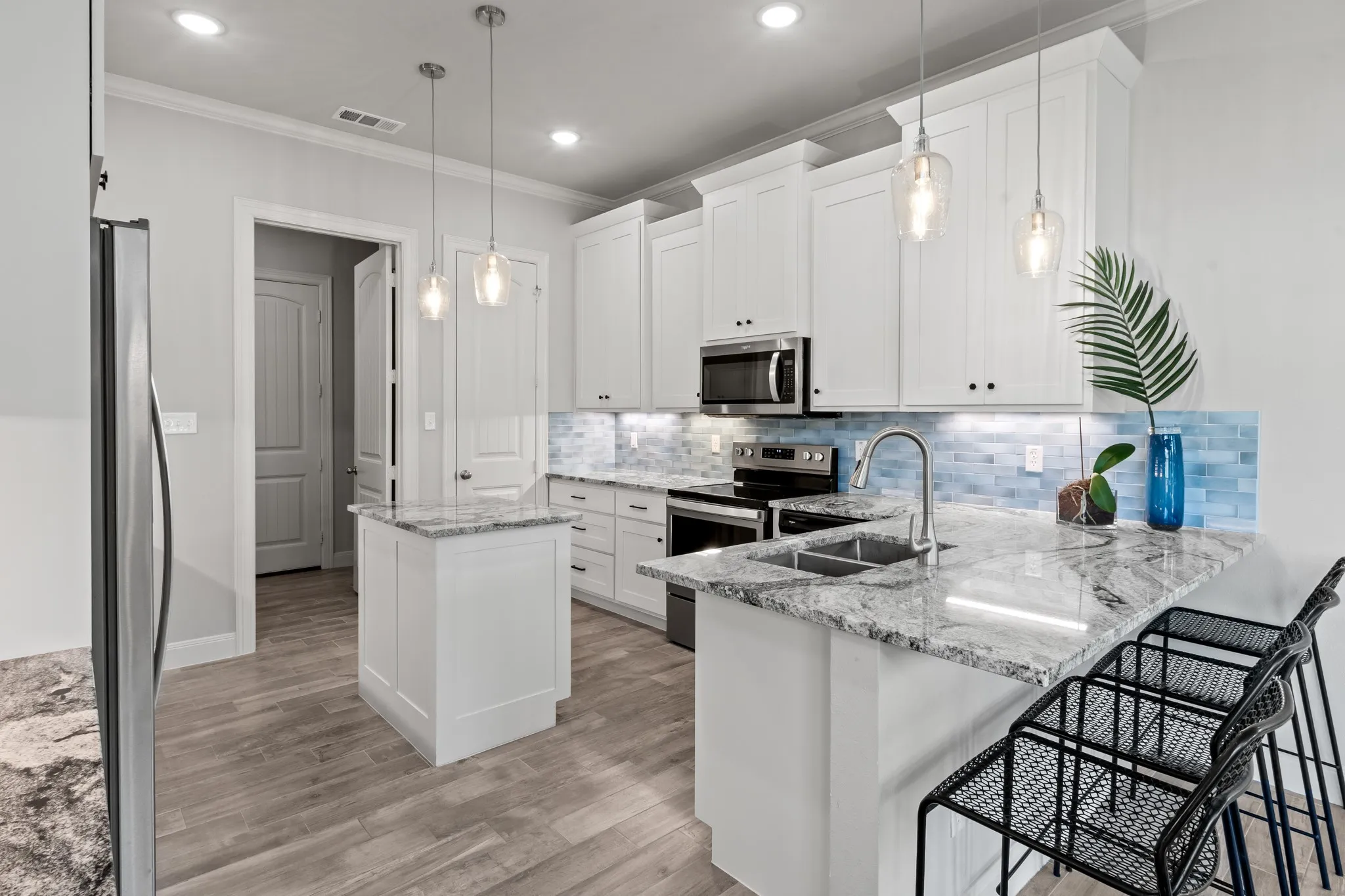 Spacious kitchen featuring stainless steel appliances and bar seating.
