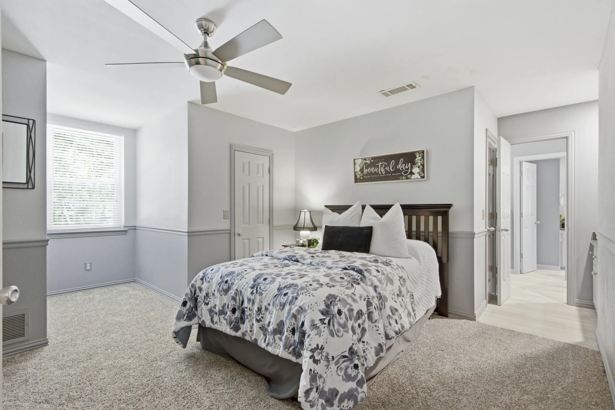 Bedroom featuring light-toned carpeting, a window with blinds, a ceiling fan with integrated lighting, and a paneled door