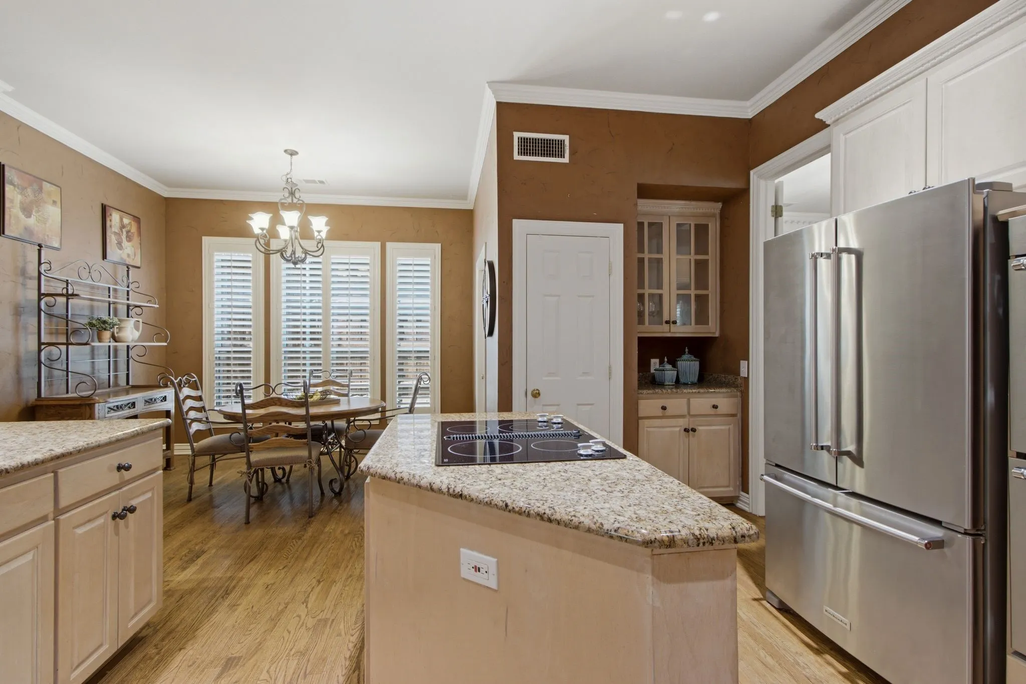 Kitchen featuring a center island with a built-in cooktop, granite countertops, and stainless steel appliances