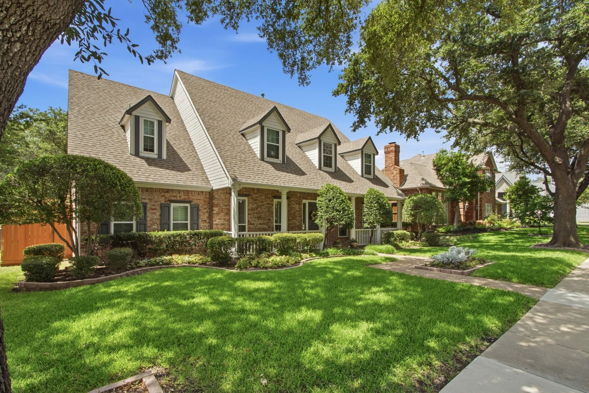 Brick exterior with white siding accents and dormer windows