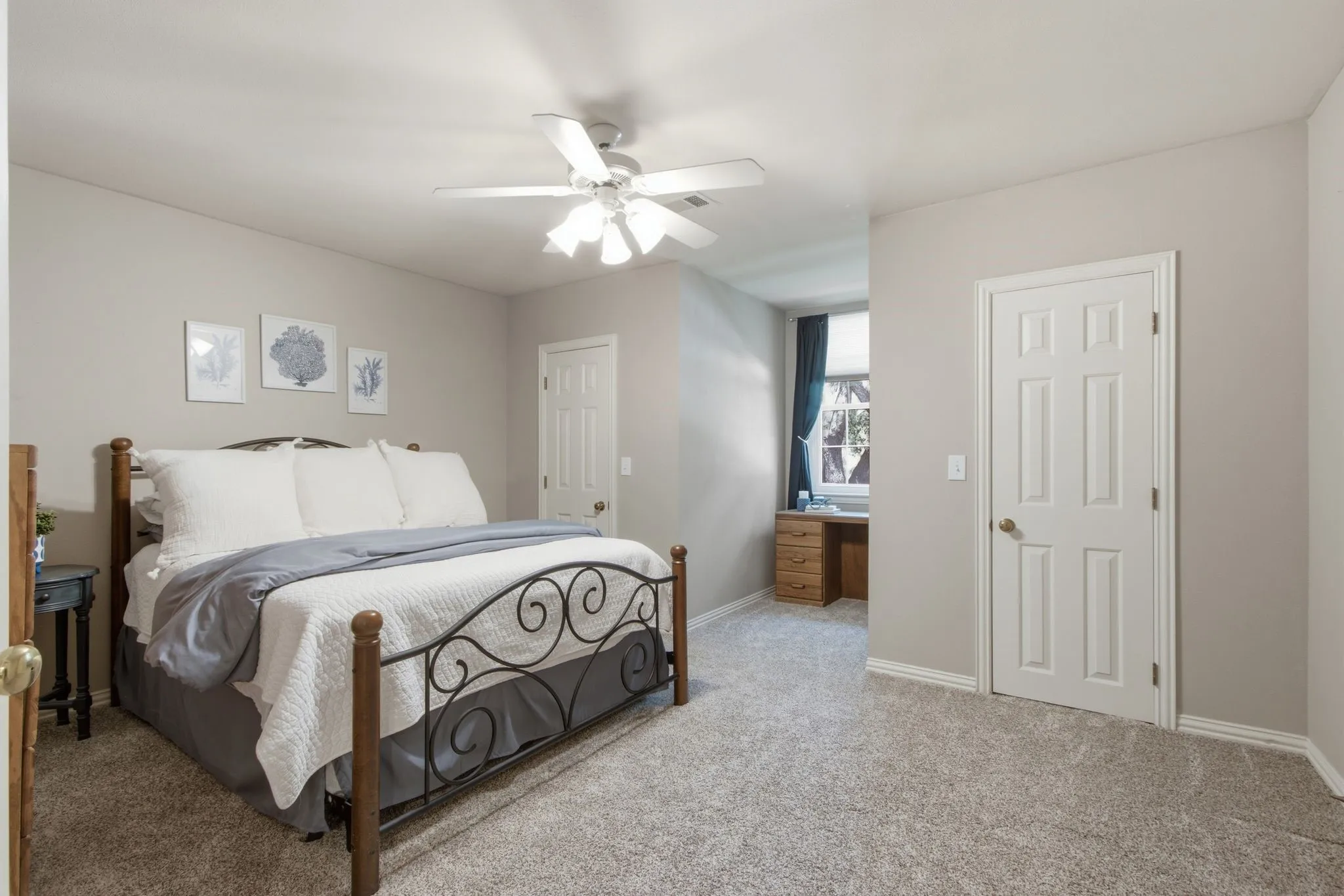 Carpeted room featuring a ceiling fan with integrated lighting, a window with dark curtains, and light-colored walls