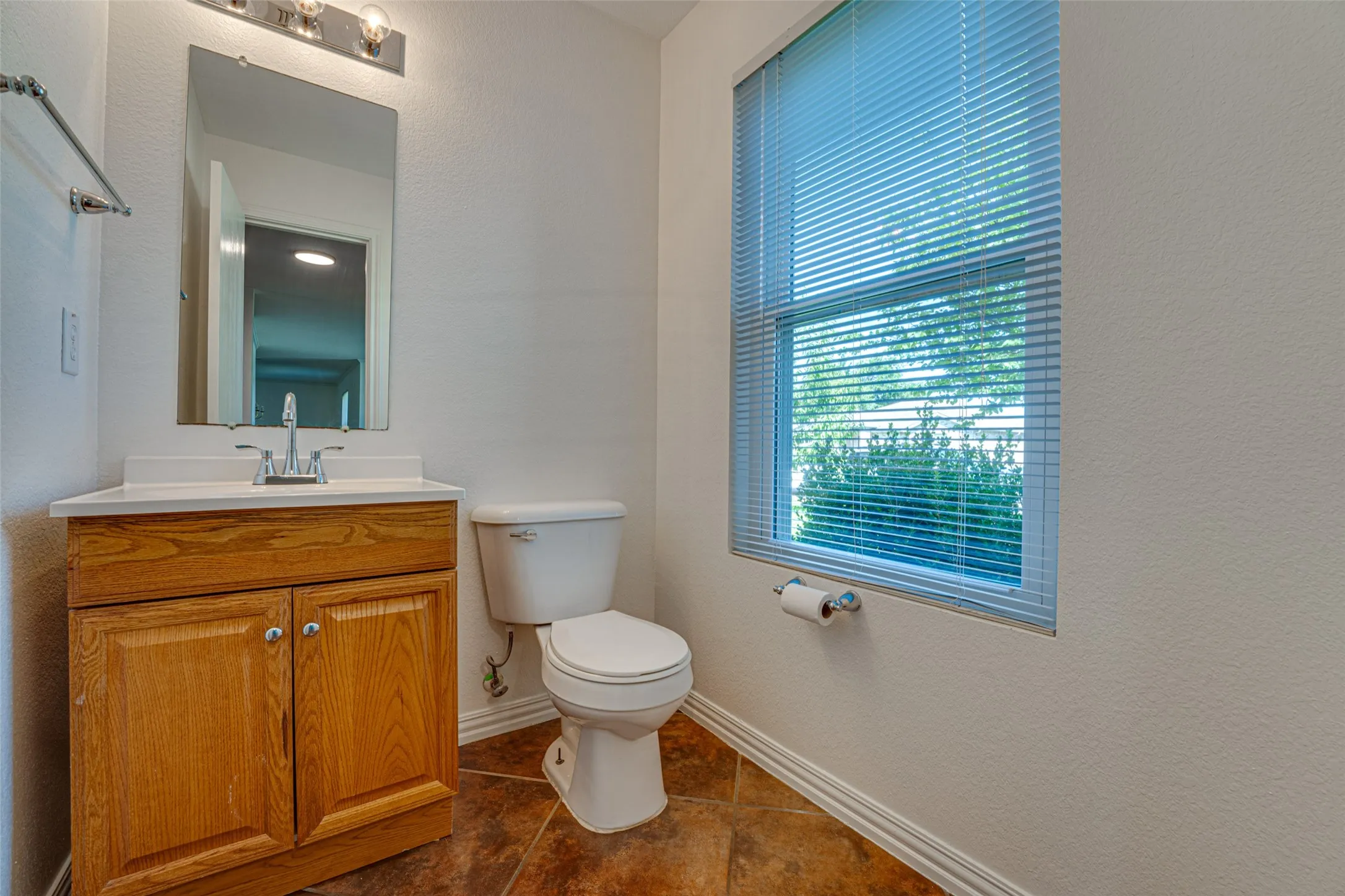 Bathroom featuring a single-sink vanity with wood-finish cabinetry and a white countertop