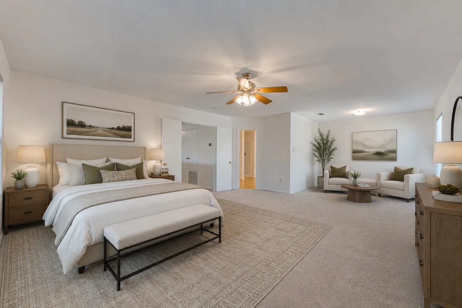 Spacious bedroom with light-colored carpeting, a ceiling fan with integrated lighting, and multiple windows