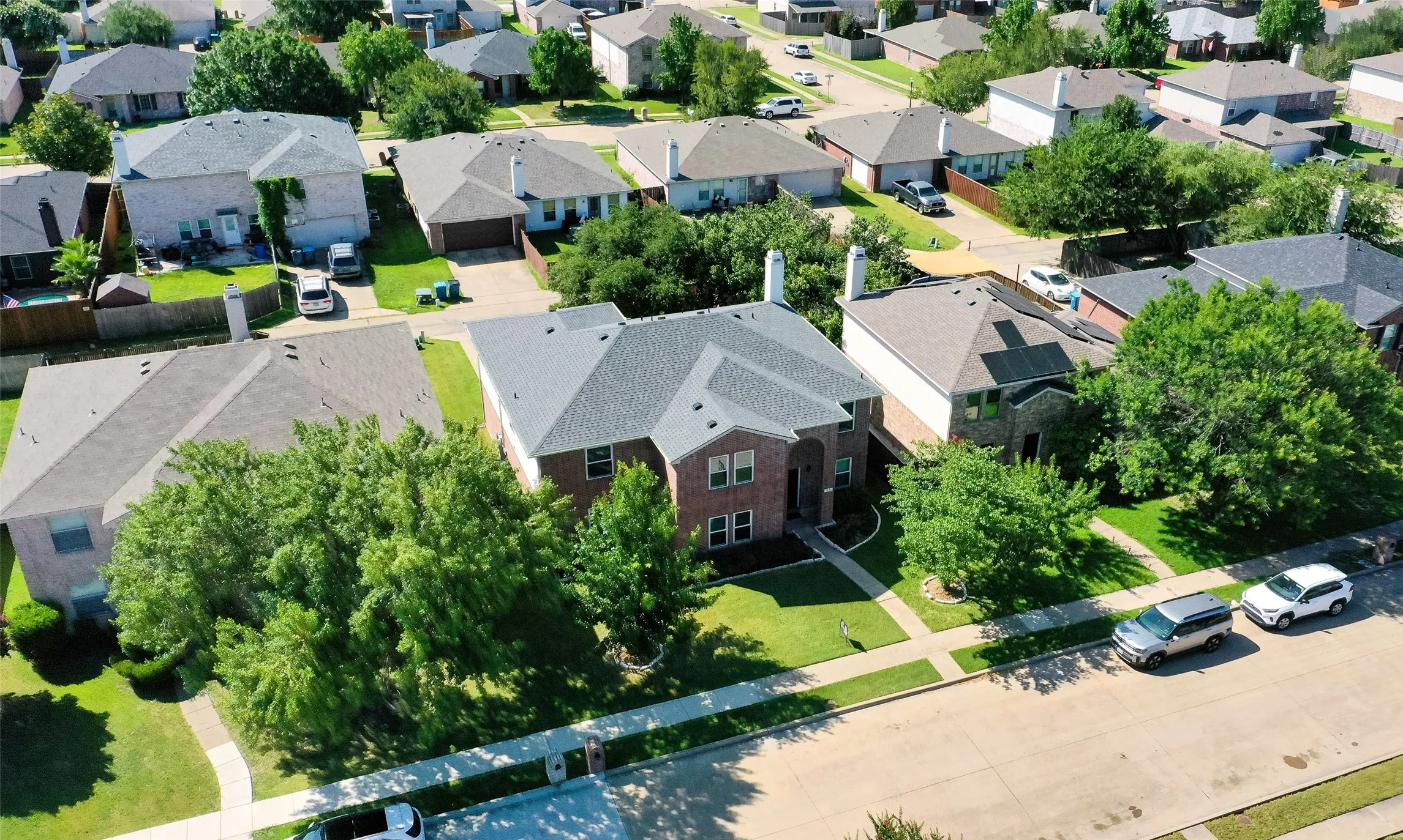 Two-story brick and siding residence with a dark shingle roof