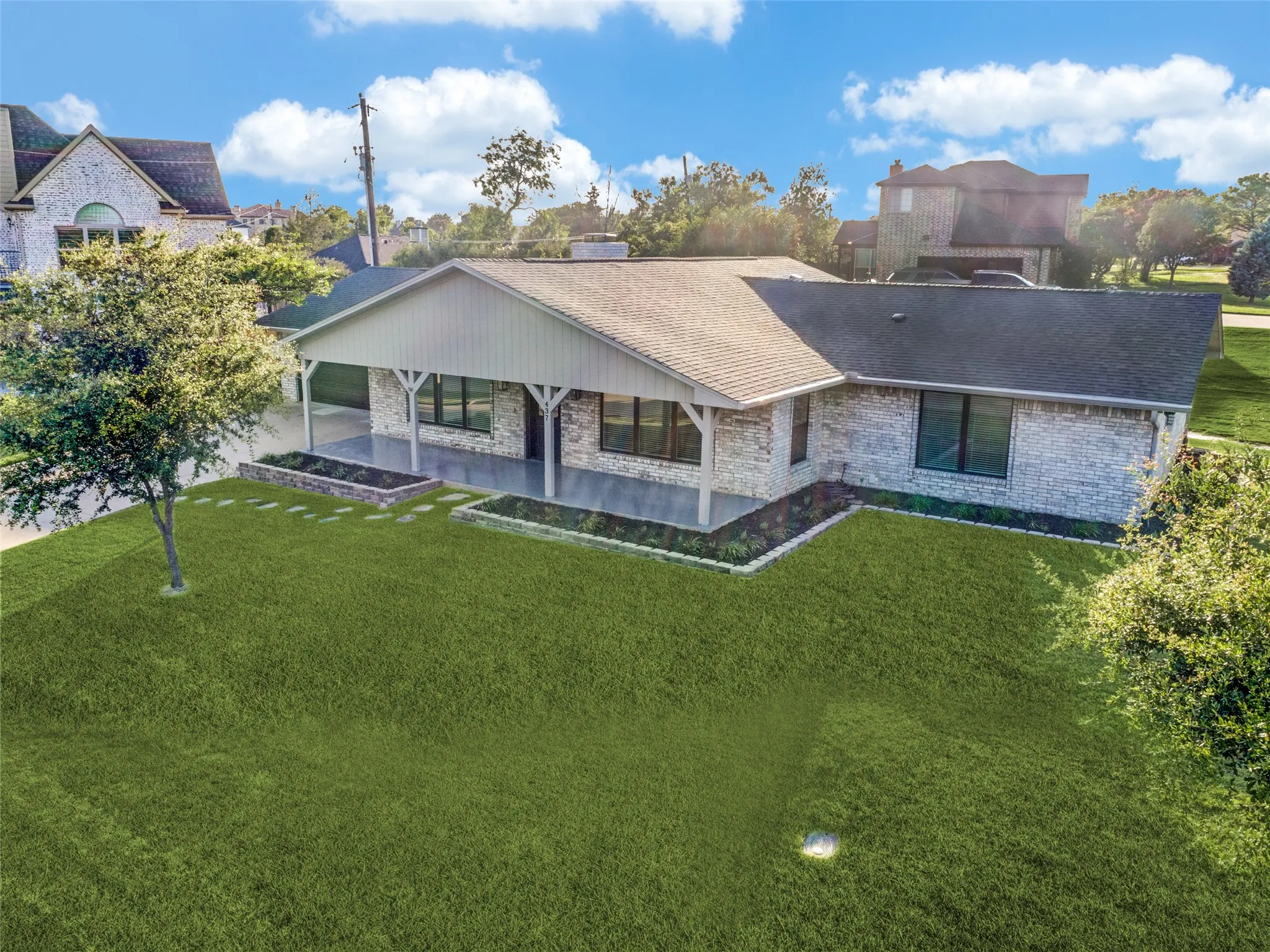 Elevated view of the front of the property showing large lot with beautiful green lush grass.