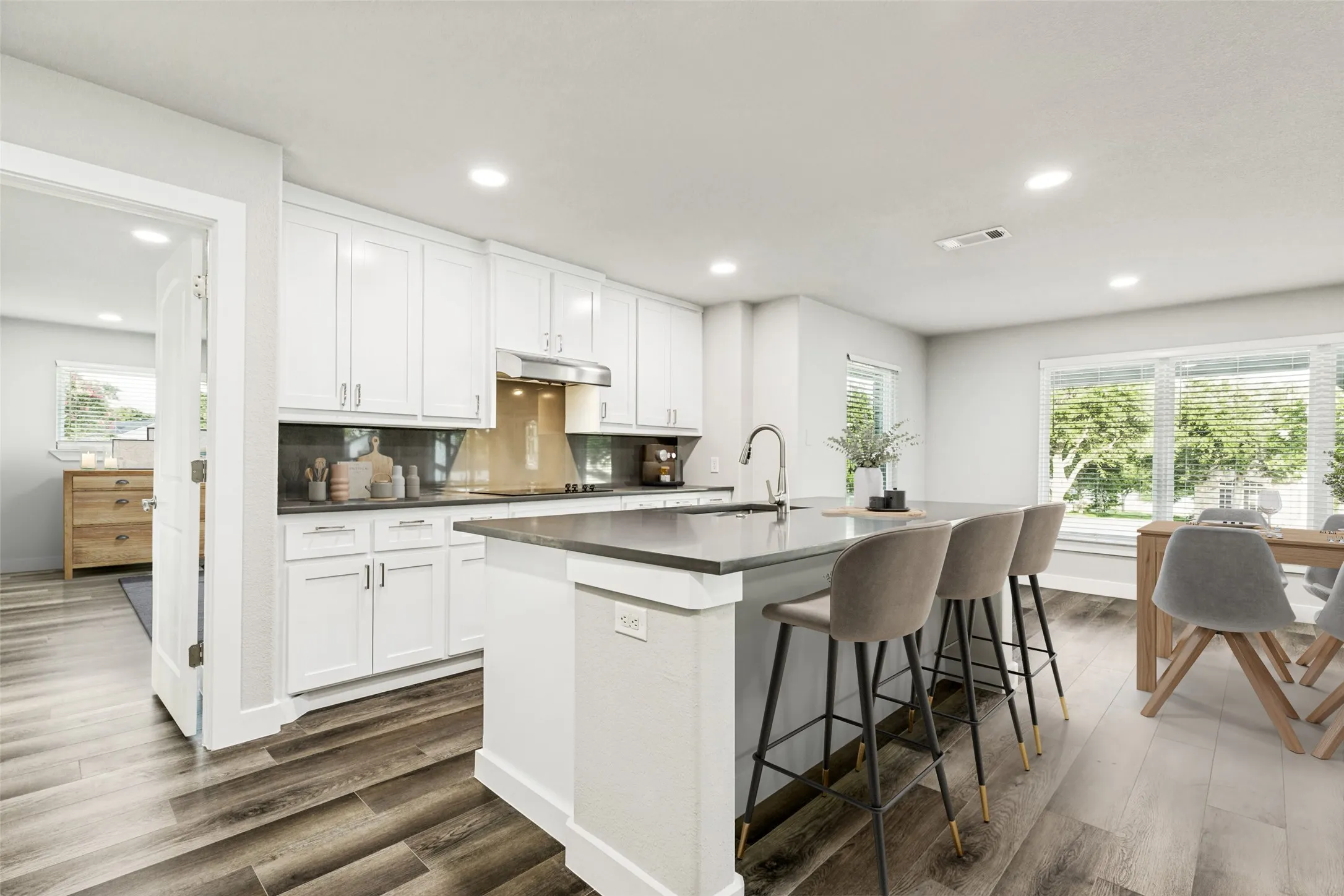 Virtually Staged-Modern kitchen with a central island featuring a sink and seating space