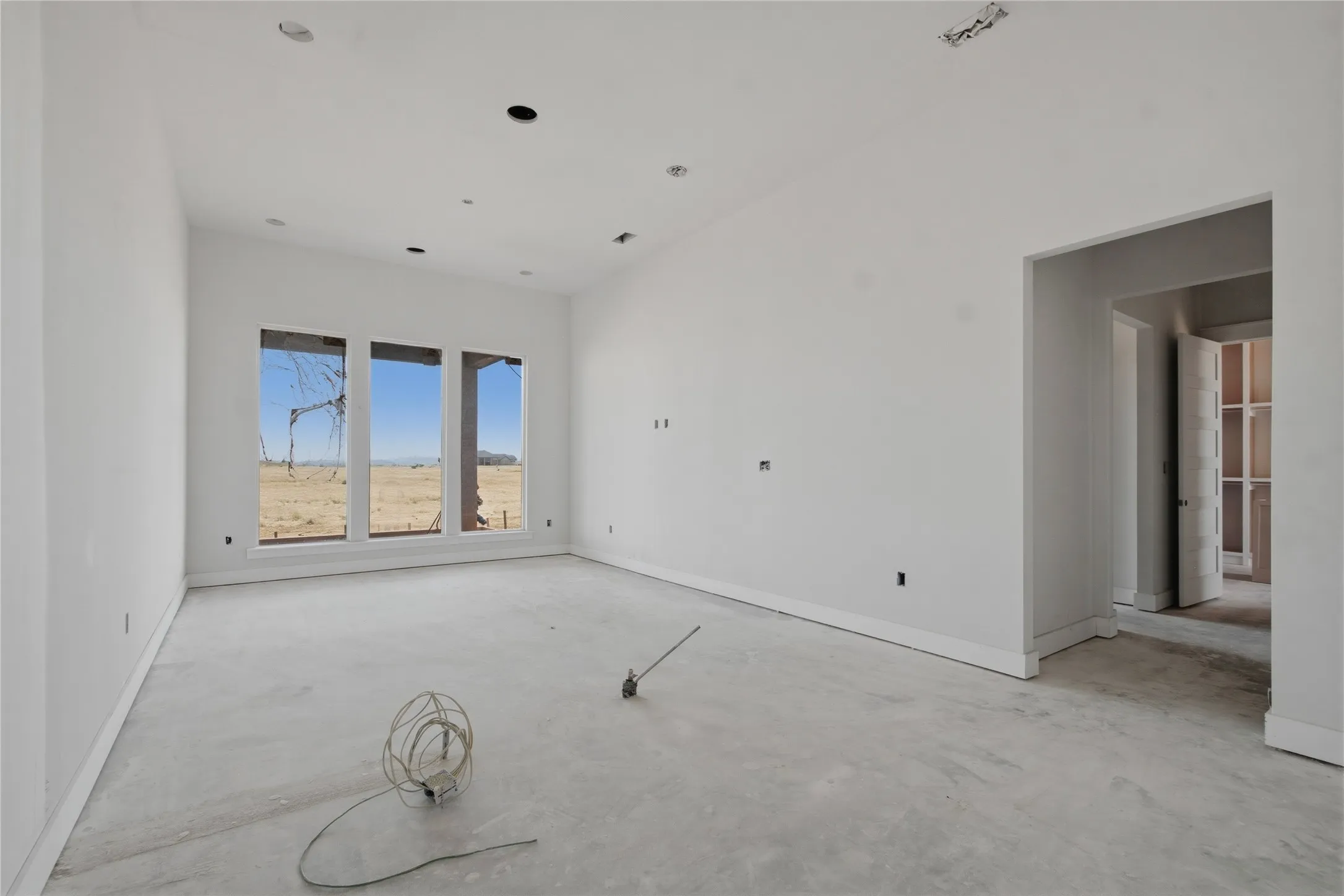 Spacious room featuring multiple large windows, recessed lighting, and a wide entryway