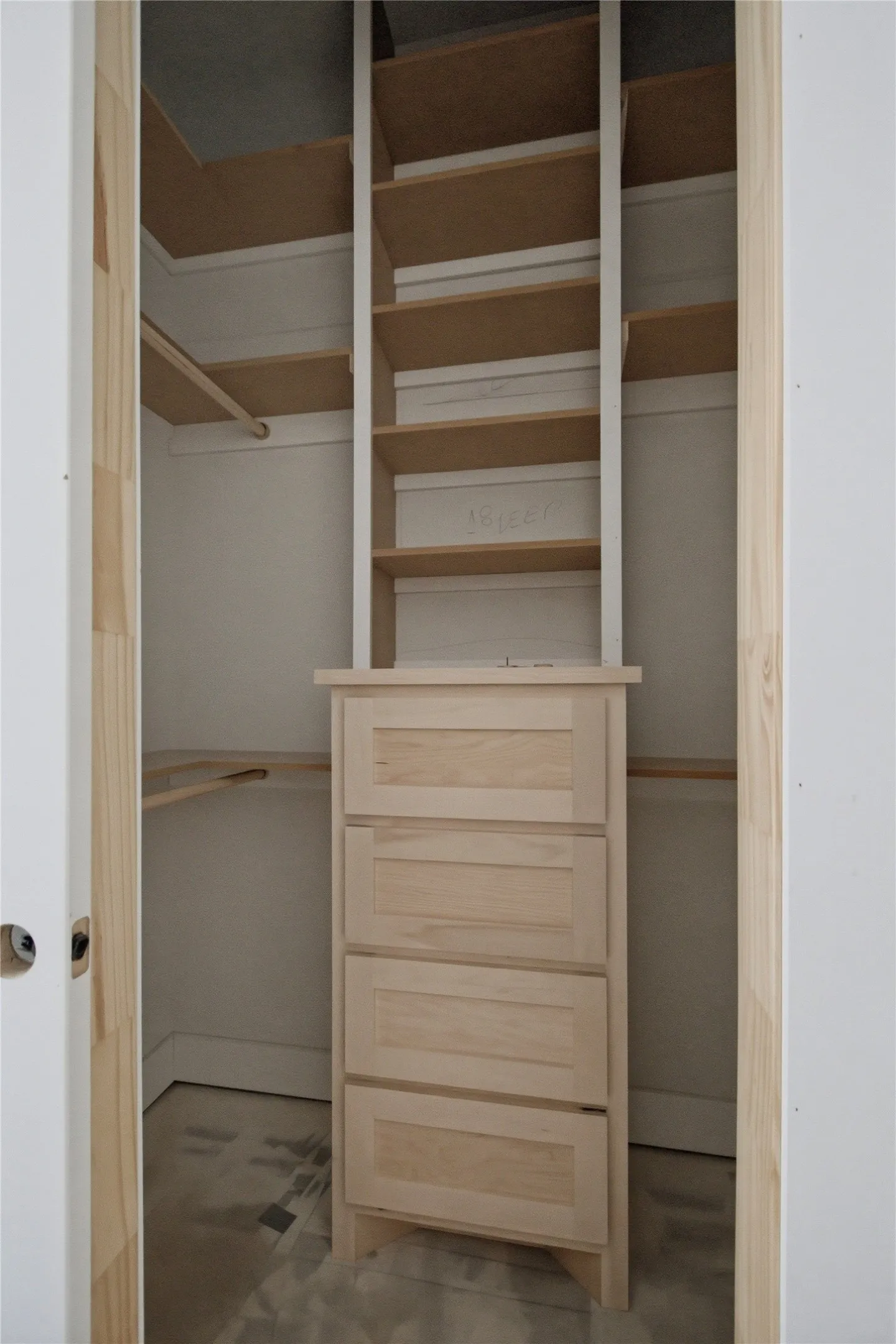 Integrated closet system featuring a four-drawer dresser, multiple shelving units, and clothing rods