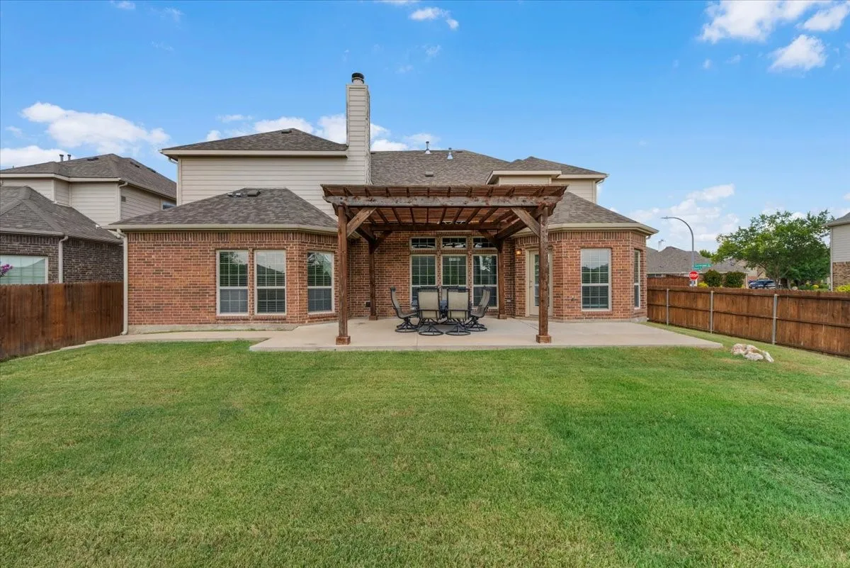 Spacious corner-lot backyard featuring a large pergola and extended patio—perfect for outdoor entertaining.
