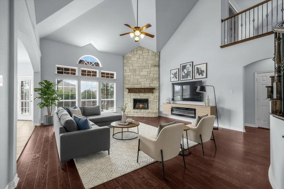 Family living room with high ceilings, stone fireplace.  **This image has been virtually staged.**
