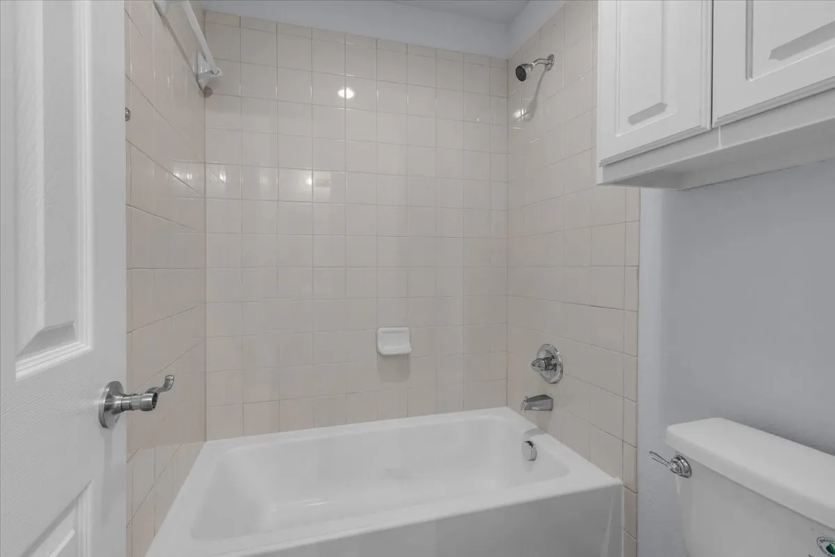 Bathtub and shower combination featuring neutral tile surround